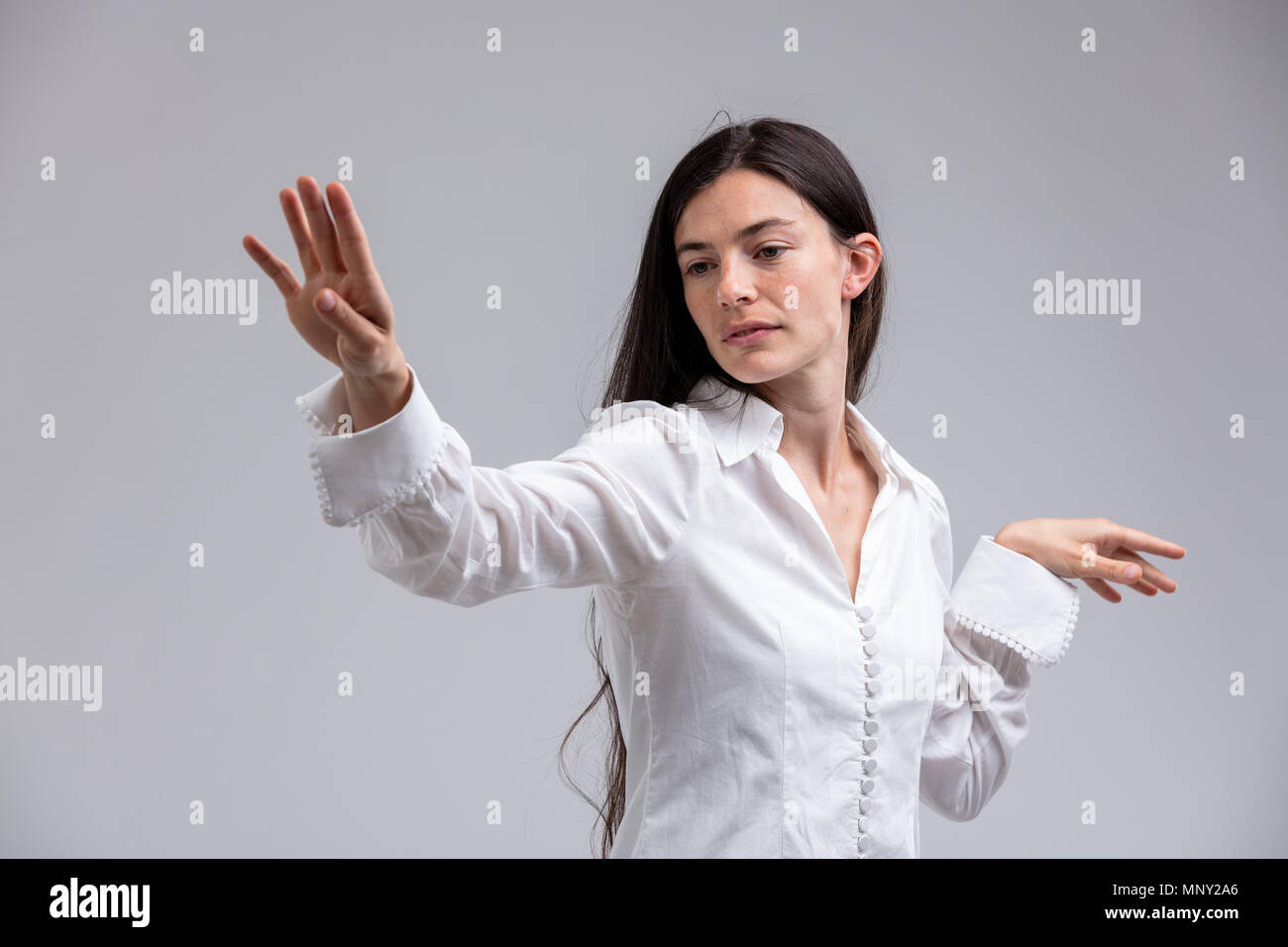 Gebieterisch hochmütige Frau, die ihre Hand flippen in Verachtung mit einem Blick der hochmütig auf Weiß isoliert Hohn Stockfoto