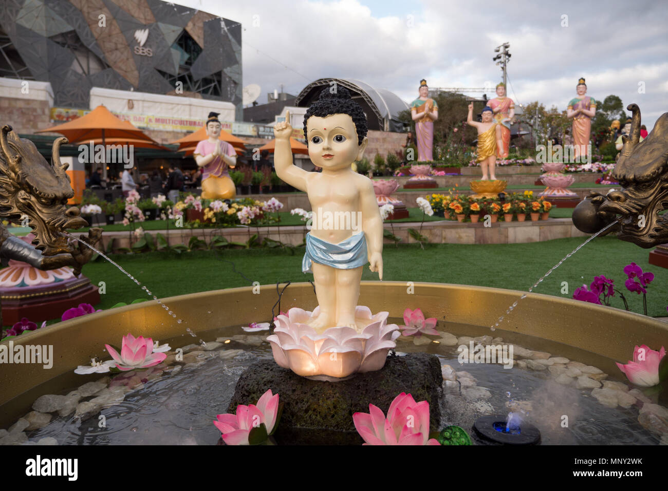 Großen Buddha Figur in Gold Gewand gehüllt, die auf Sky stehend auf Golden Lotus mit großen Masse von Menschen in den Hintergrund. Stockfoto