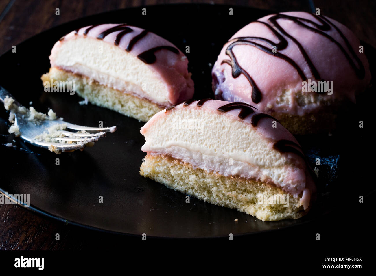 Hälfte in Stücke geschnittenen Princess Rosa Sahnetorte mit Marzipan/Marzipan und Schokolade Sauce. Traditionelle Dessert. Stockfoto