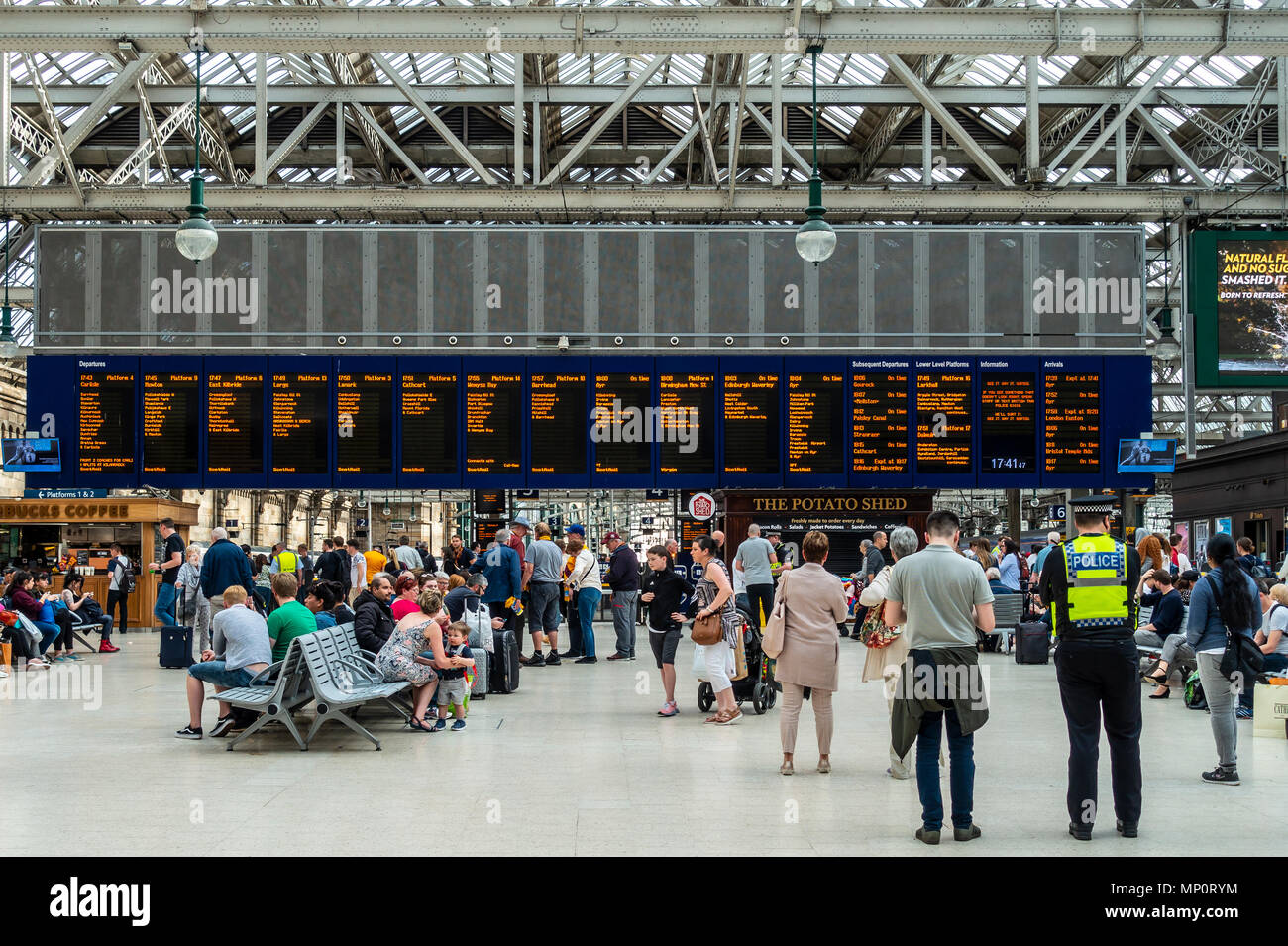 Passagiere warten auf Züge vor der Anzeigetafel in der bahnhofshalle Hauptbahnhof Glasgow, Glasgow, Schottland, Großbritannien Stockfoto