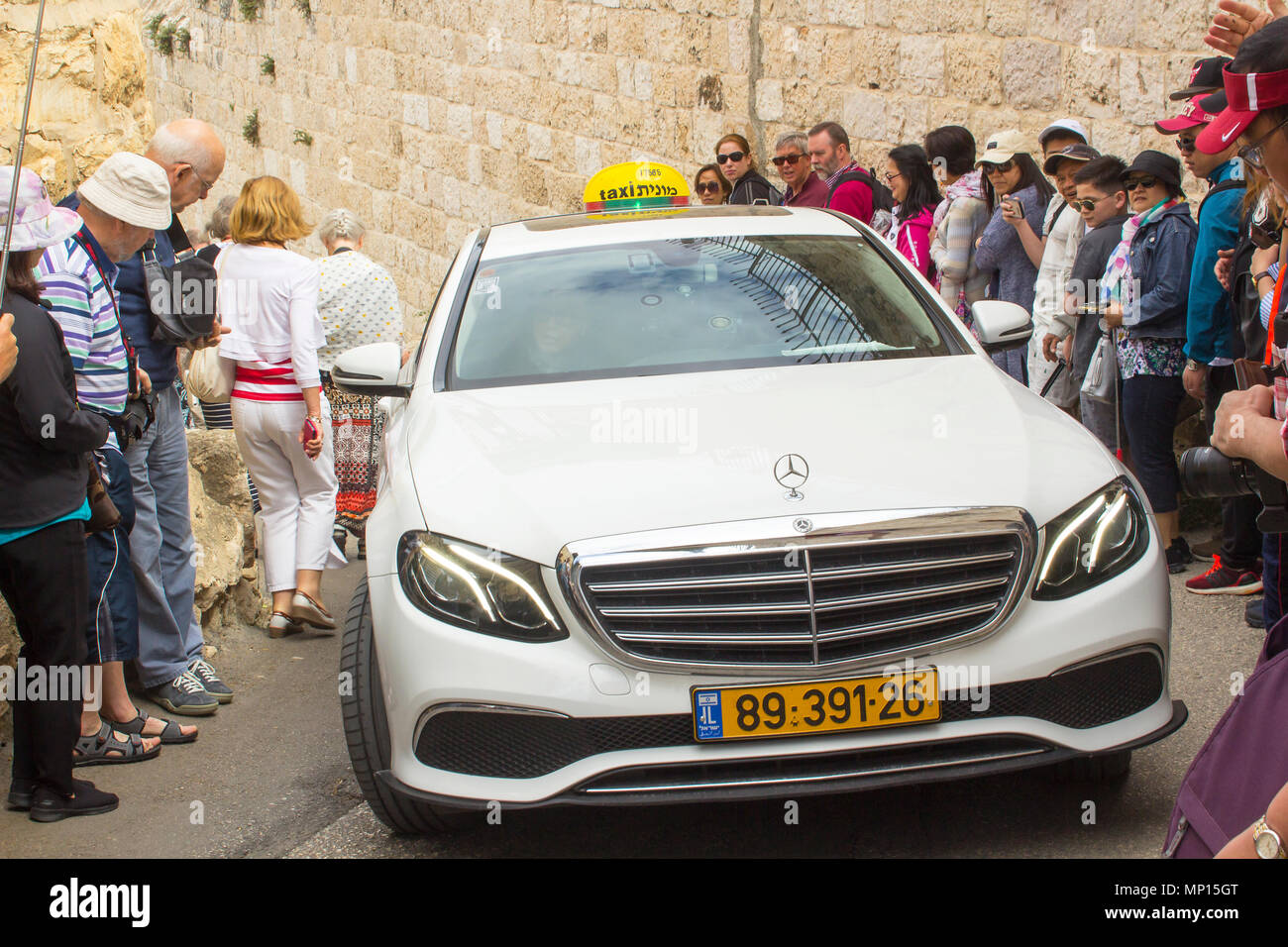 Touristen den Weg für ein Taxi, da es langsam nach oben verschiebt die steilen Hügel der Allee zum Garten von Gethsemene auf dem Ölberg in Jerusalem. Stockfoto