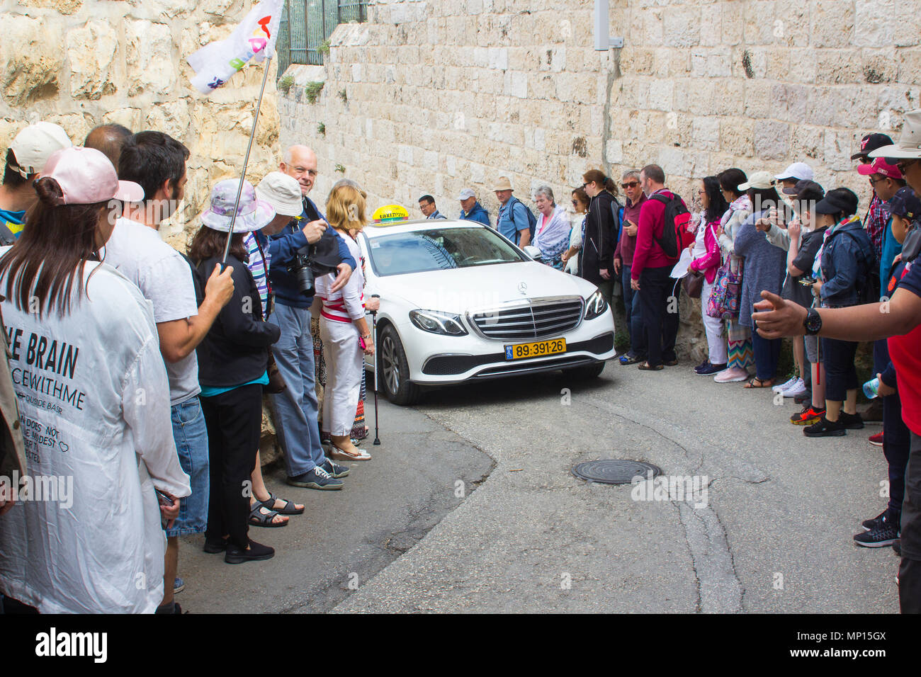 Touristen den Weg für ein Taxi, da es langsam nach oben verschiebt die steilen Hügel der Allee zum Garten von Gethsemene auf dem Ölberg in Jerusalem. Stockfoto
