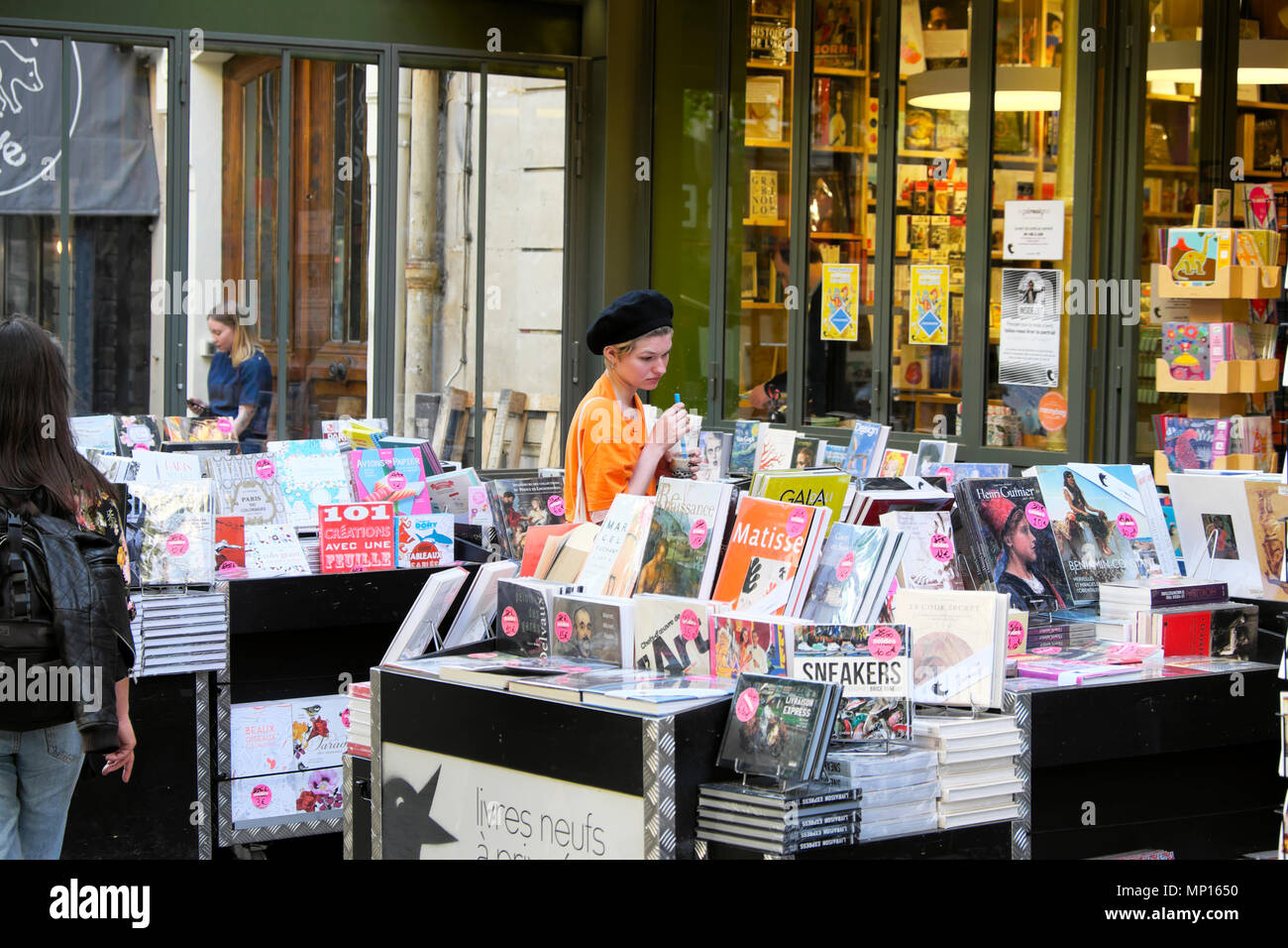Eine junge Frau das Tragen einer Baskenmütze surfen Bücher außerhalb einer französischen Buchhandlung in der Rue Mouffetard Straße im Zentrum von Paris Frankreich EU KATHY DEWITT Stockfoto
