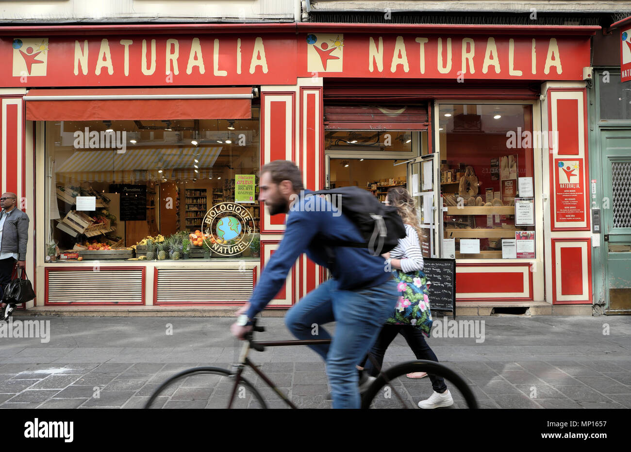 Mann auf dem Fahrrad Radfahren durch Naturalia Bioladen in der Rue Mouffetard Straße in der Nähe von Les Halles Paris Frankreich Europa KATHY DEWITT Stockfoto