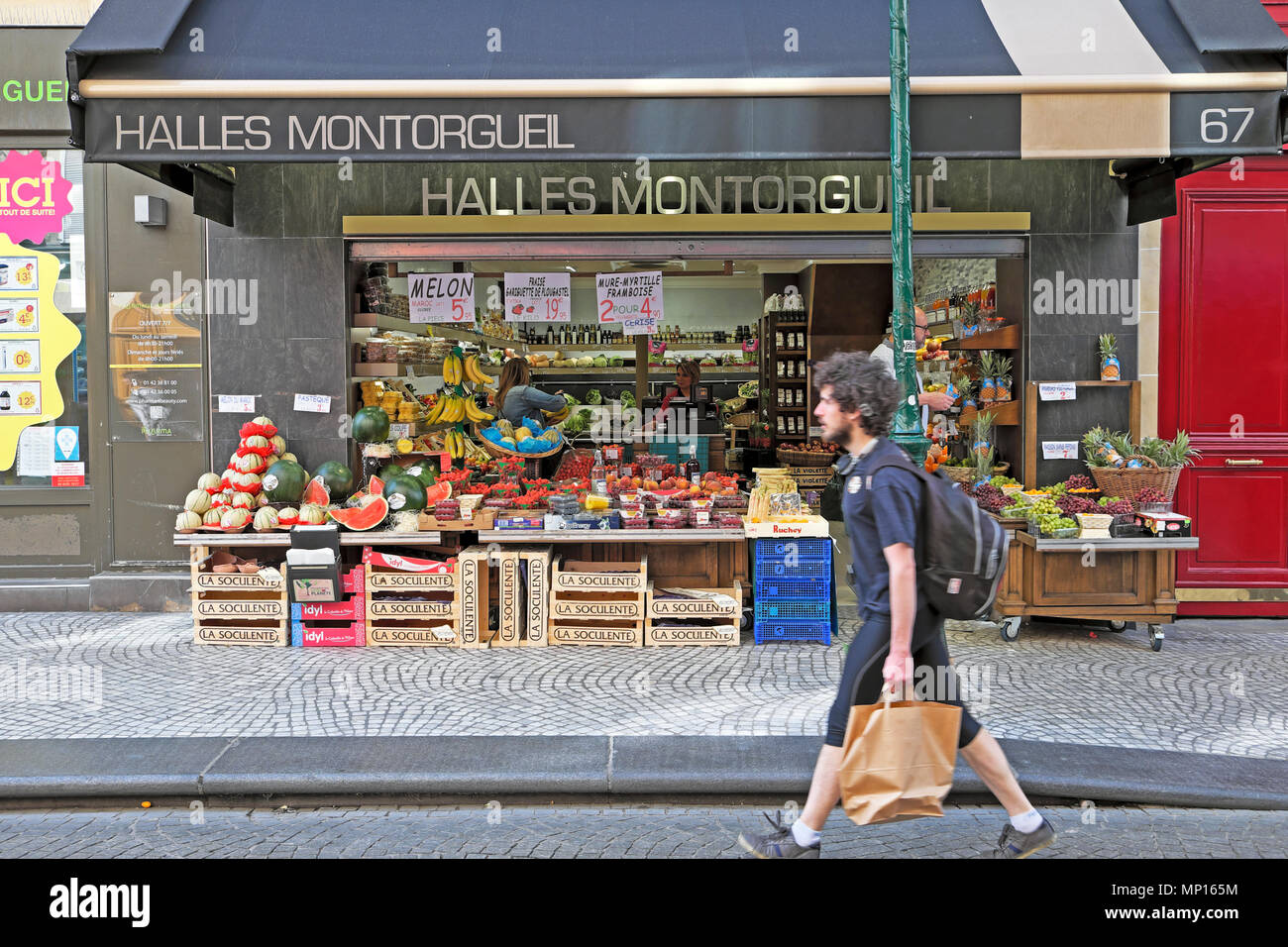Mann mit Einkaufstasche wandern entlang der Rue Mouffetard Straße vorbei Halles Beaubourg Obst und Gemüse Laden in Paris Frankreich Europa EU-KATHY DEWITT Stockfoto