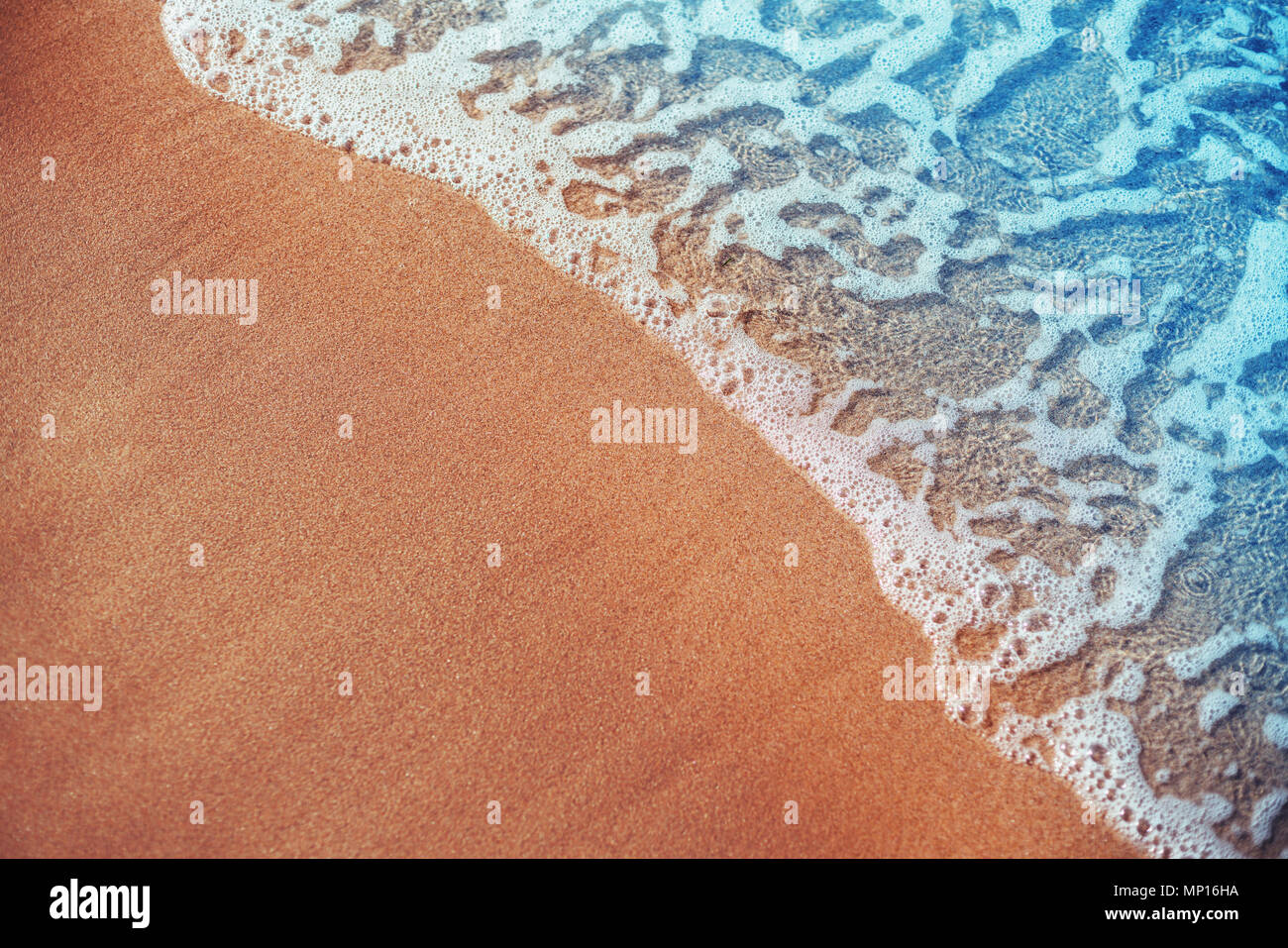 Weiche Welle des blauen Ozeans am Sandstrand. Hintergrund. Stockfoto