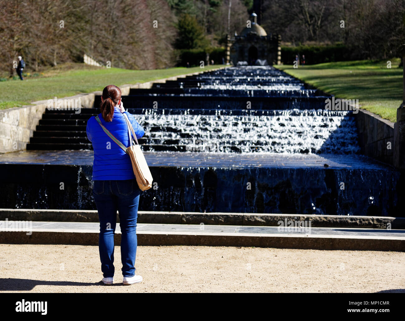 Eine Dame Tourist, der ein Foto von der Kaskade auf dem Gelände des Chatsworth House in der Nähe von Bakewell in Derbyshire Stockfoto