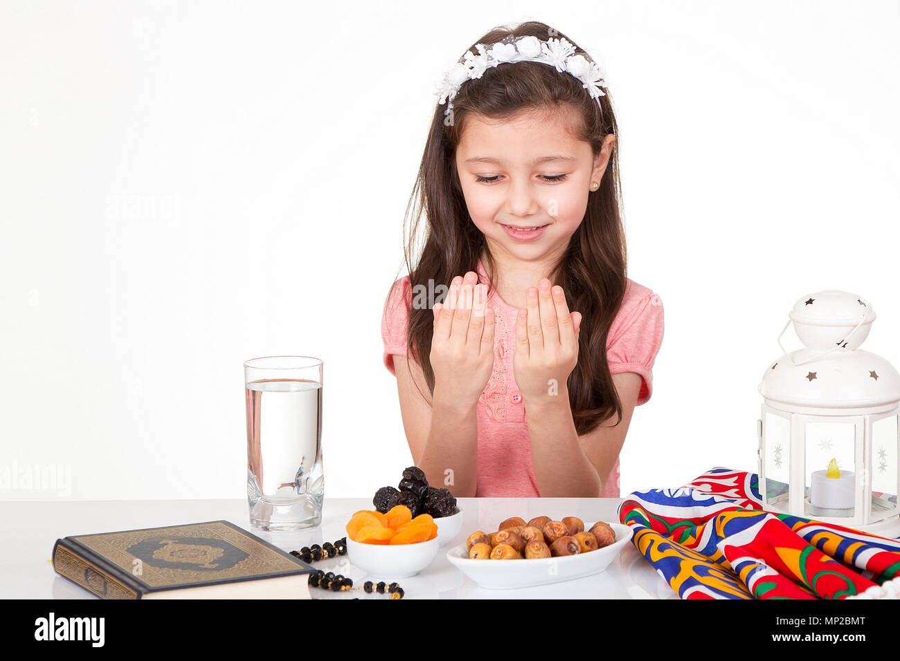 Junge muslimische Mädchen beten zu Allah beim Warten auf iftar (Frühstück) im Ramadan Stockfoto