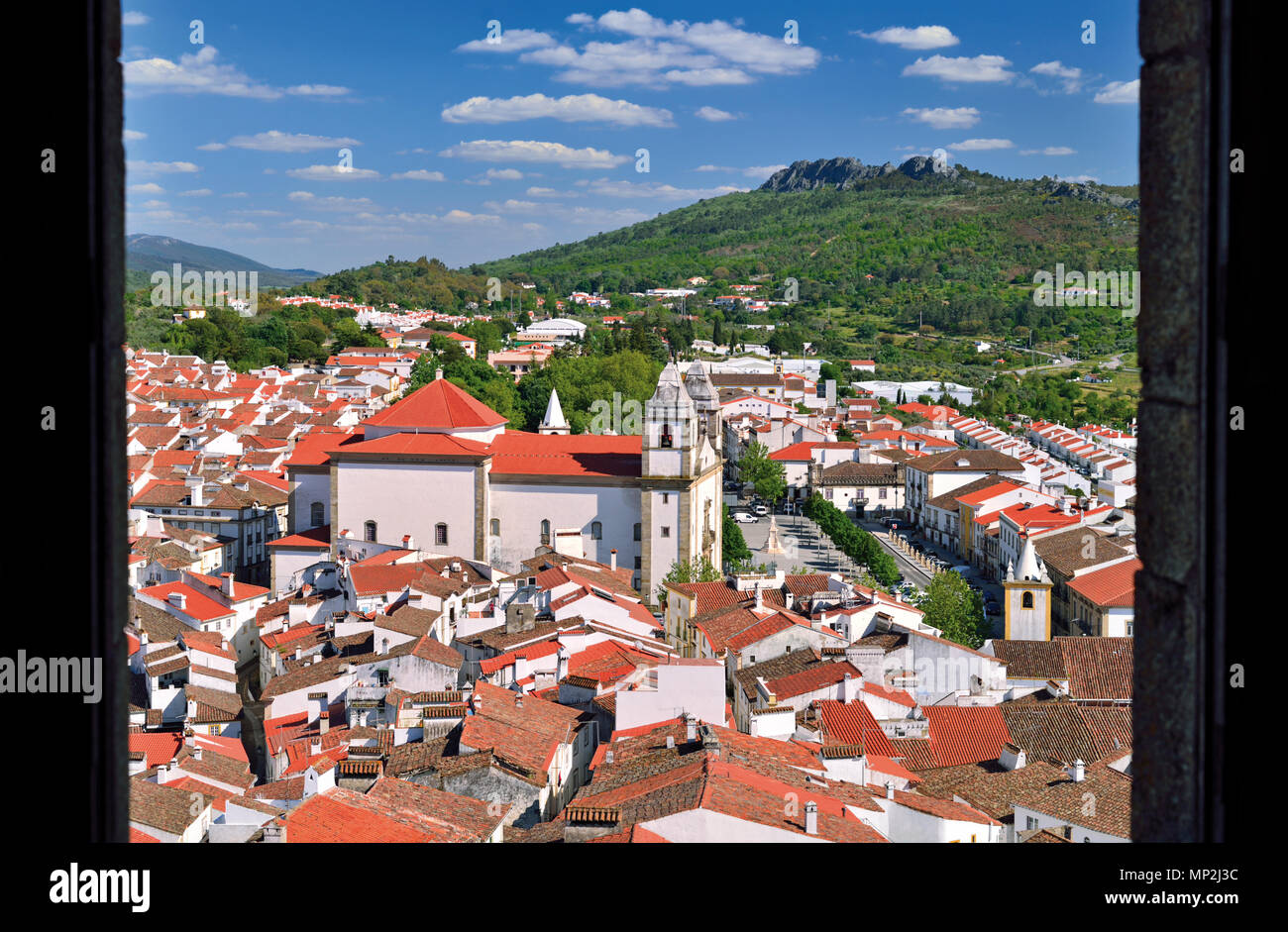 Blick durch eine mittelalterliche Burg Fenster kleine Stadt mit den Bergen im Hintergrund Stockfoto