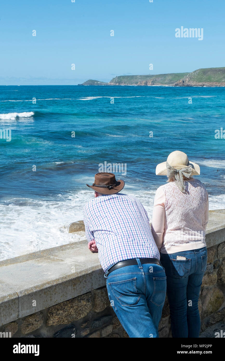 Besucher genießen den Blick über das Meer in Sennen Cove in Cornwall. Stockfoto