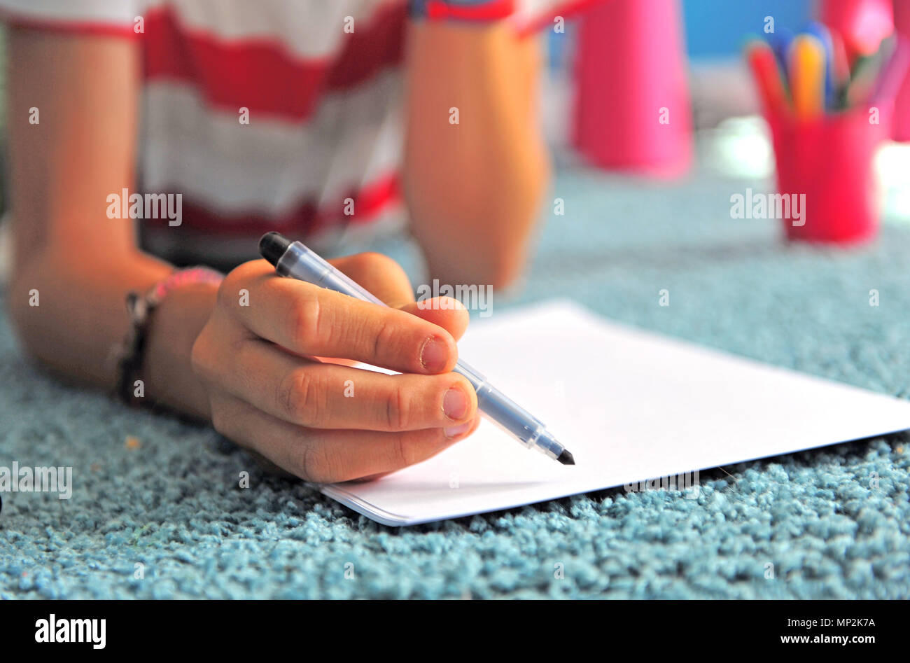 Kinder- hand mit einem Stift und Papier Stockfoto