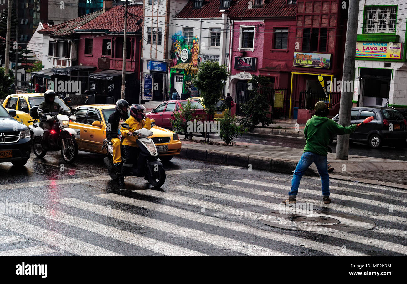 Ein Jongleur unterhaltsame warten Verkehr auf einen Fußgängerüberweg im Regen in Bogota Kolumbien Stockfoto