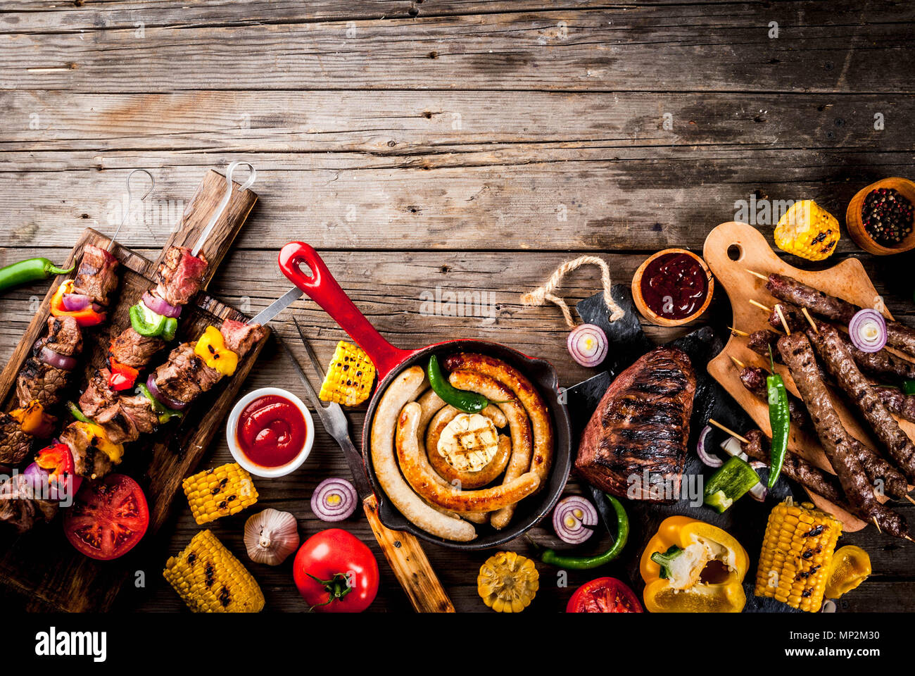 Sortiment verschiedene Barbecue Grill Fleisch, bbq Party fest - Shish Kebab, Würstchen, gegrillten Fleisch Filet, frisches Gemüse, Soßen, Gewürze, auf alten Woo Stockfoto