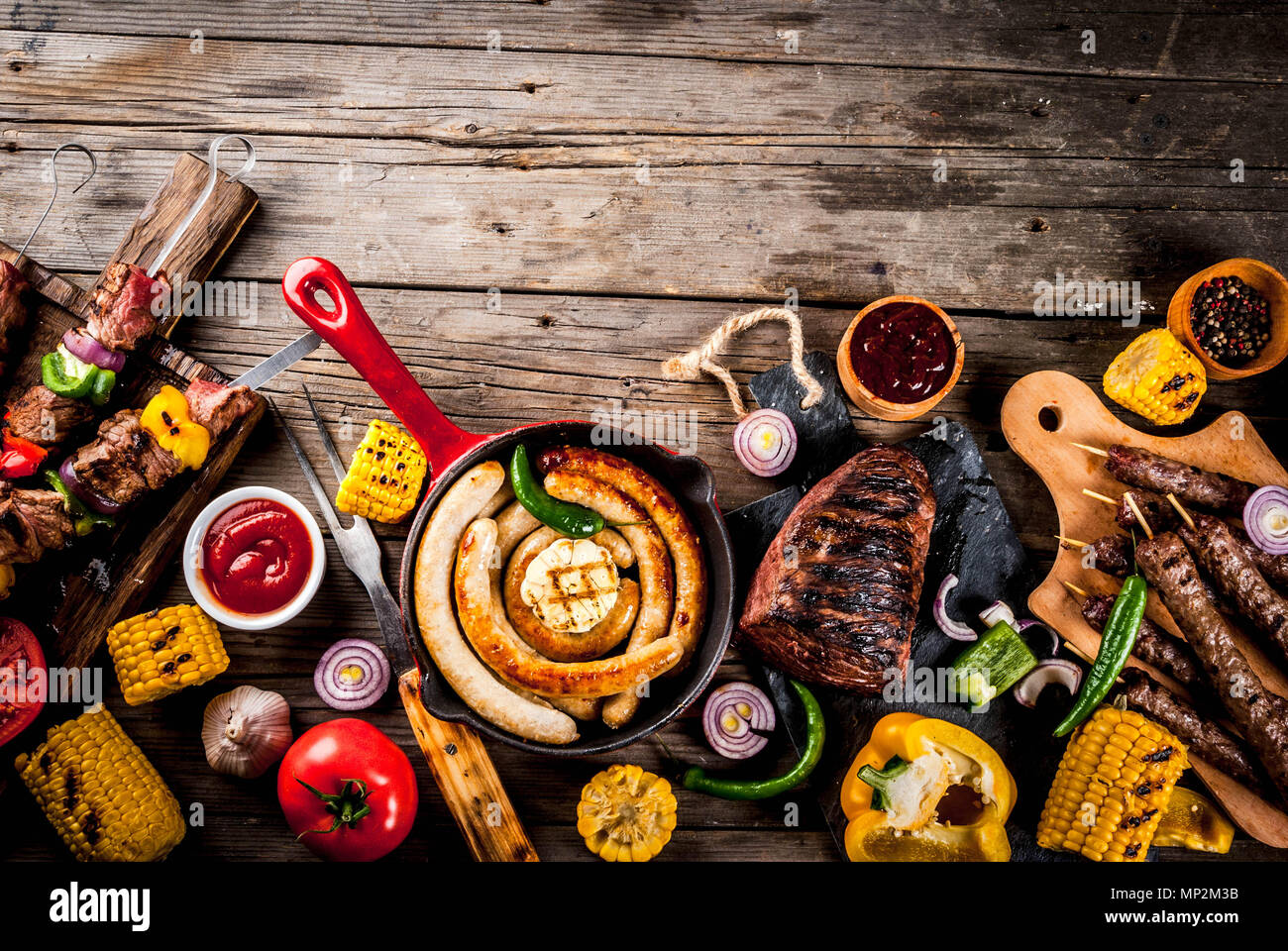 Sortiment verschiedene Barbecue Grill Fleisch, bbq Party fest - Shish Kebab, Würstchen, gegrillten Fleisch Filet, frisches Gemüse, Soßen, Gewürze, auf alten Woo Stockfoto