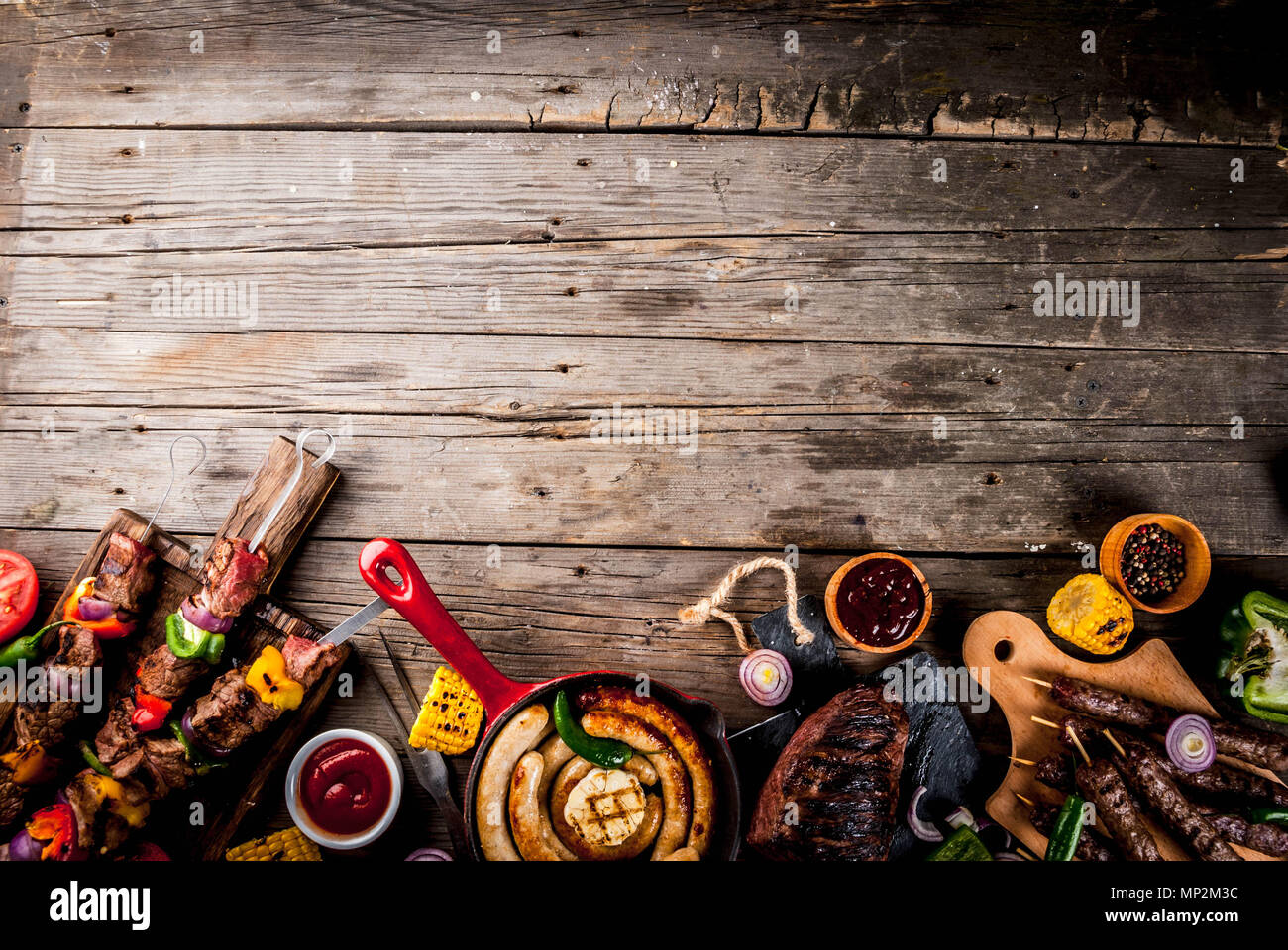 Sortiment verschiedene Barbecue Grill Fleisch, bbq Party fest - Shish Kebab, Würstchen, gegrillten Fleisch Filet, frisches Gemüse, Soßen, Gewürze, auf alten Woo Stockfoto