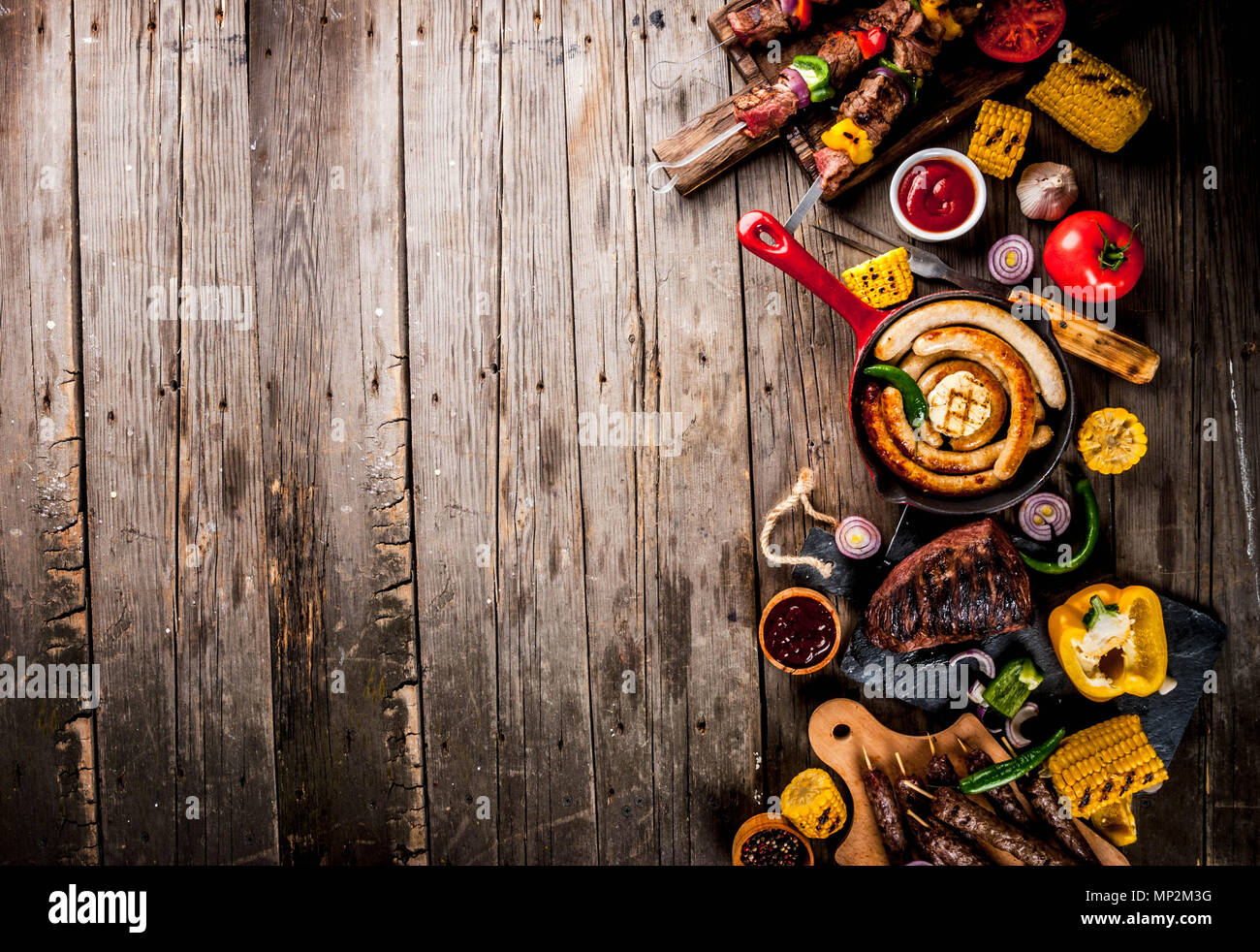 Sortiment verschiedene Barbecue Grill Fleisch, bbq Party fest - Shish Kebab, Würstchen, gegrillten Fleisch Filet, frisches Gemüse, Soßen, Gewürze, auf alten Woo Stockfoto