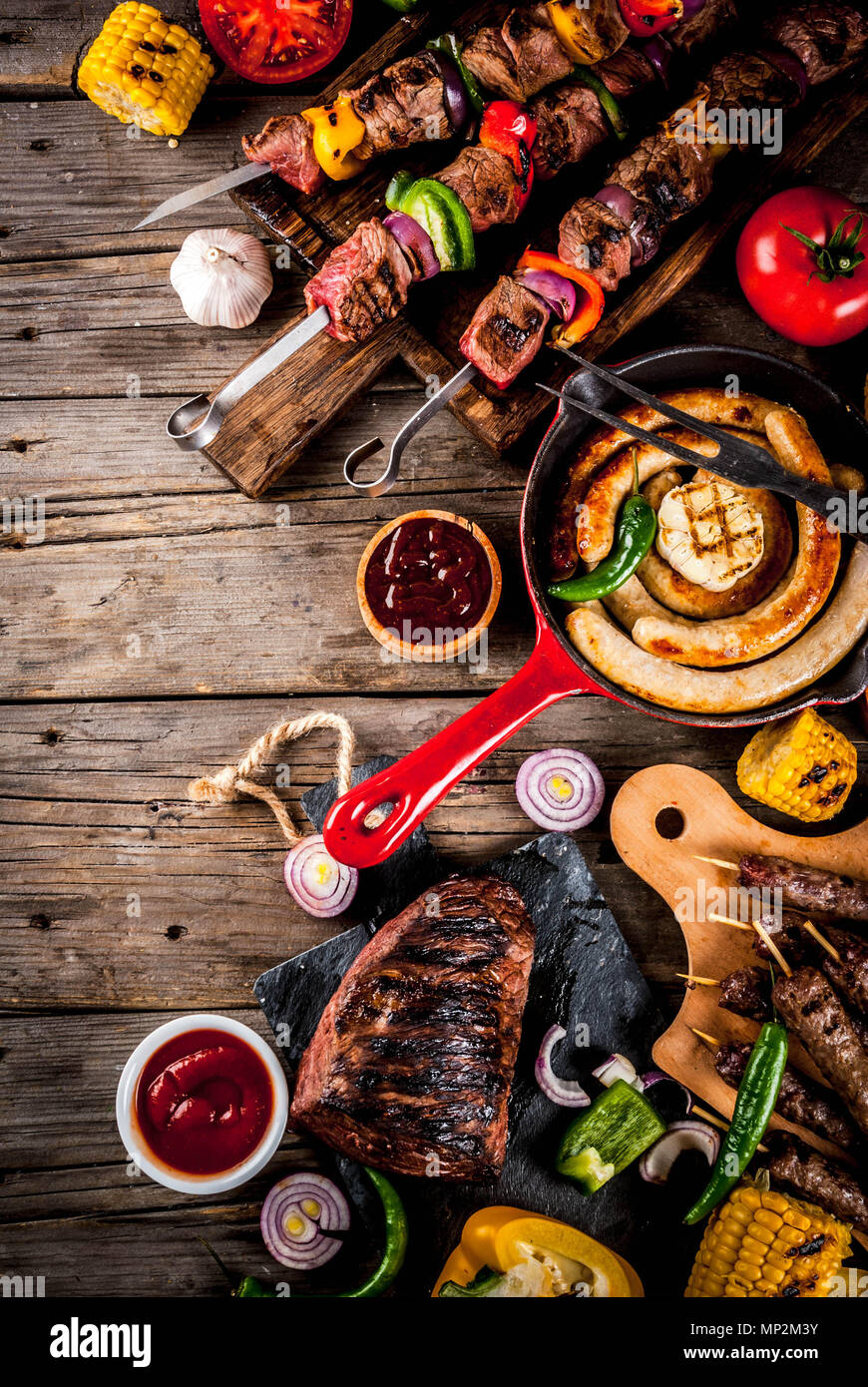 Sortiment verschiedene Barbecue Grill Fleisch, bbq Party fest - Shish Kebab, Würstchen, gegrillten Fleisch Filet, frisches Gemüse, Soßen, Gewürze, auf alten Woo Stockfoto
