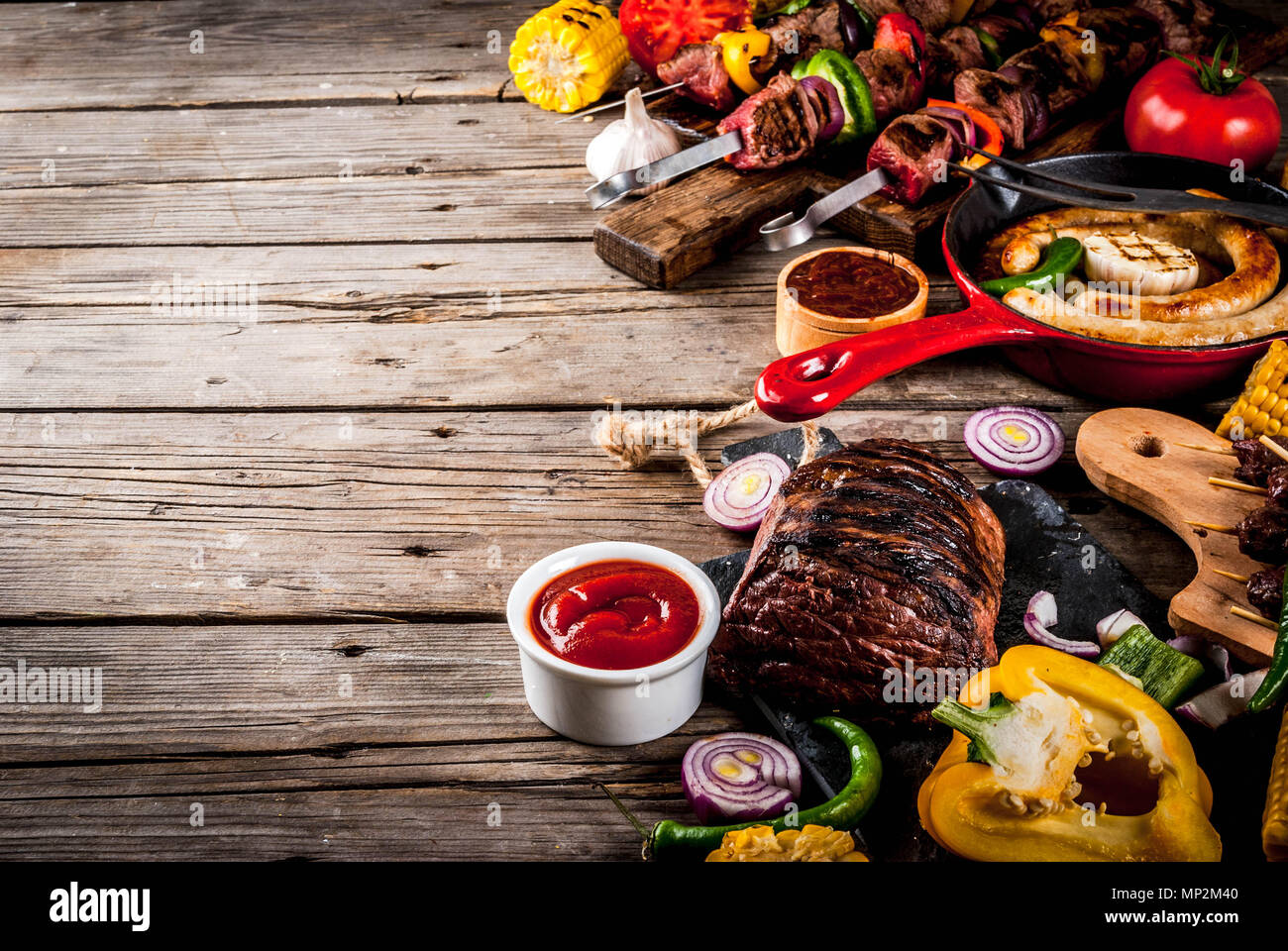 Sortiment verschiedene Barbecue Grill Fleisch, bbq Party fest - Shish Kebab, Würstchen, gegrillten Fleisch Filet, frisches Gemüse, Soßen, Gewürze, auf alten Woo Stockfoto