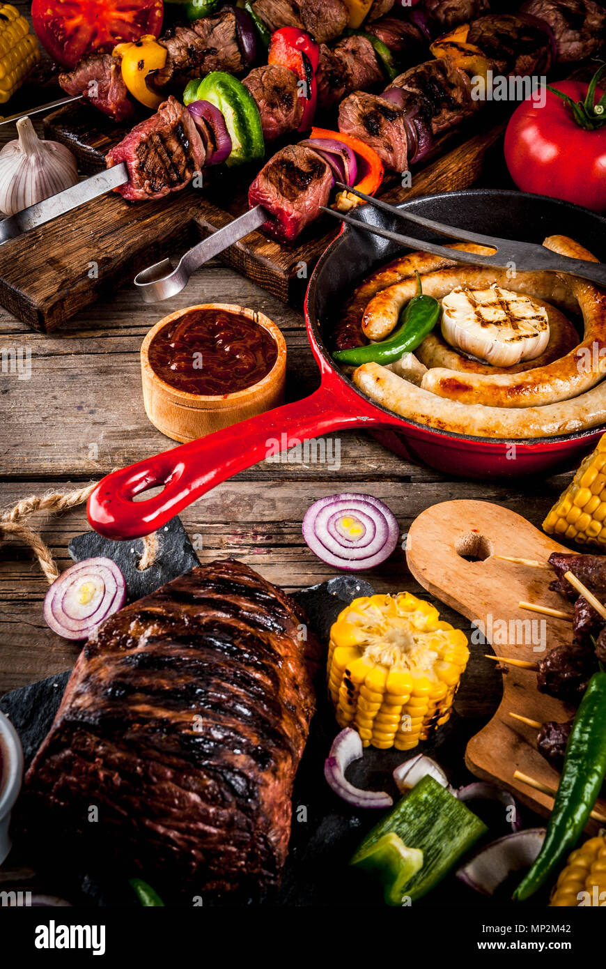 Sortiment verschiedene Barbecue Grill Fleisch, bbq Party fest - Shish Kebab, Würstchen, gegrillten Fleisch Filet, frisches Gemüse, Soßen, Gewürze, auf alten Woo Stockfoto