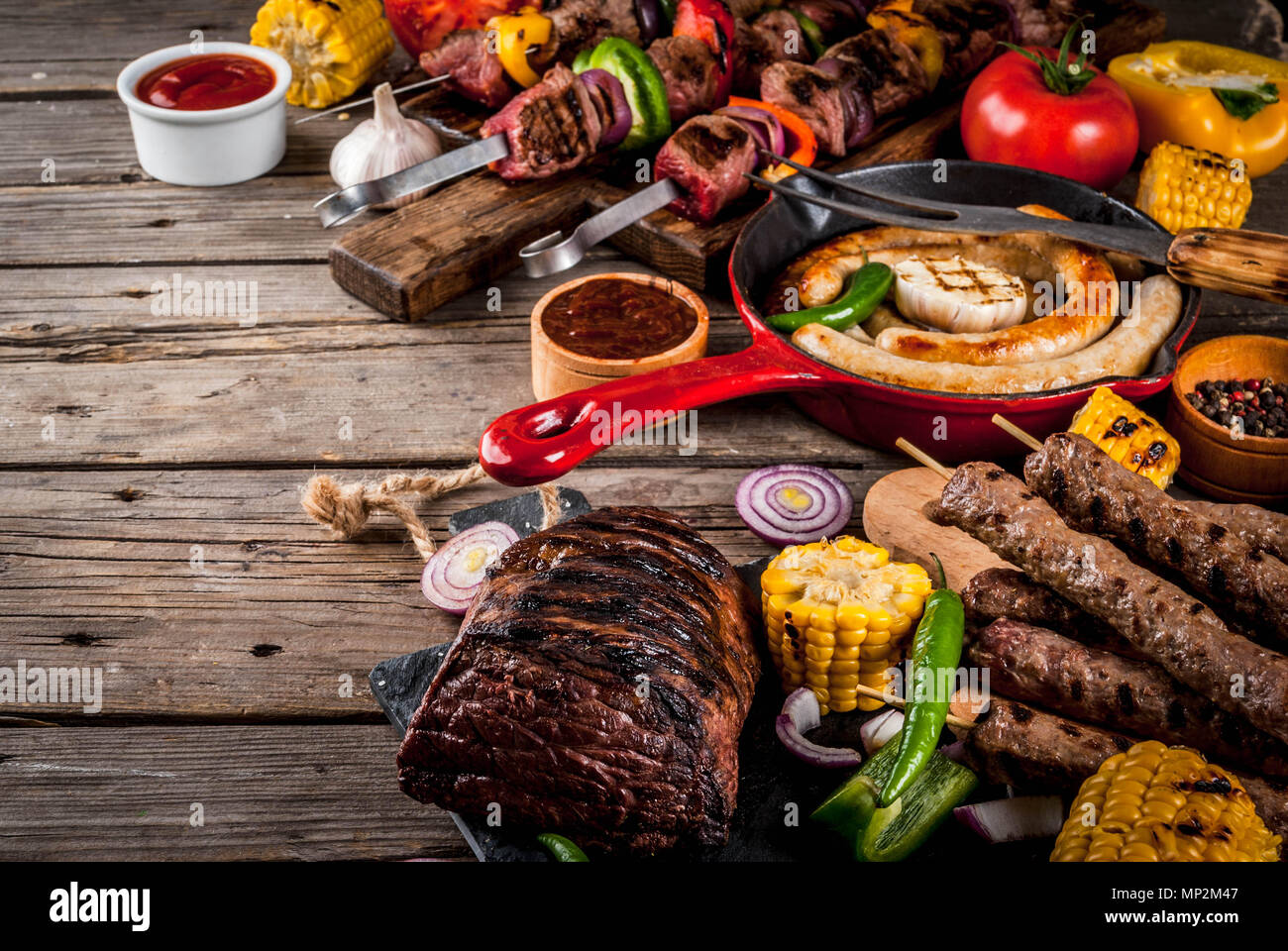 Sortiment verschiedene Barbecue Grill Fleisch, bbq Party fest - Shish Kebab, Würstchen, gegrillten Fleisch Filet, frisches Gemüse, Soßen, Gewürze, auf alten Woo Stockfoto