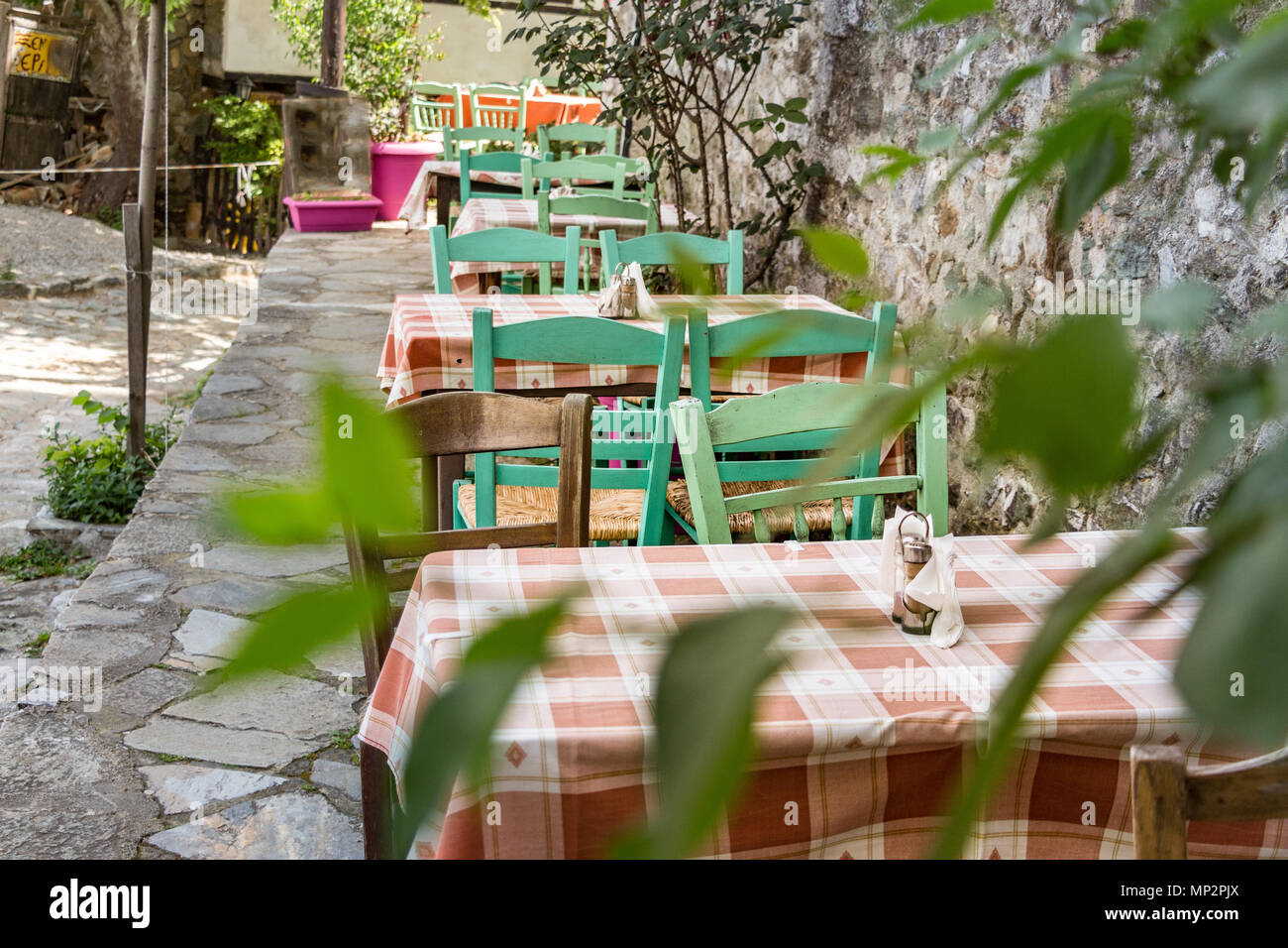 Griechische Taverne Holz- bunten Stühlen und Tisch im Freien an Palios Panteleimonas, Griechenland. Stockfoto