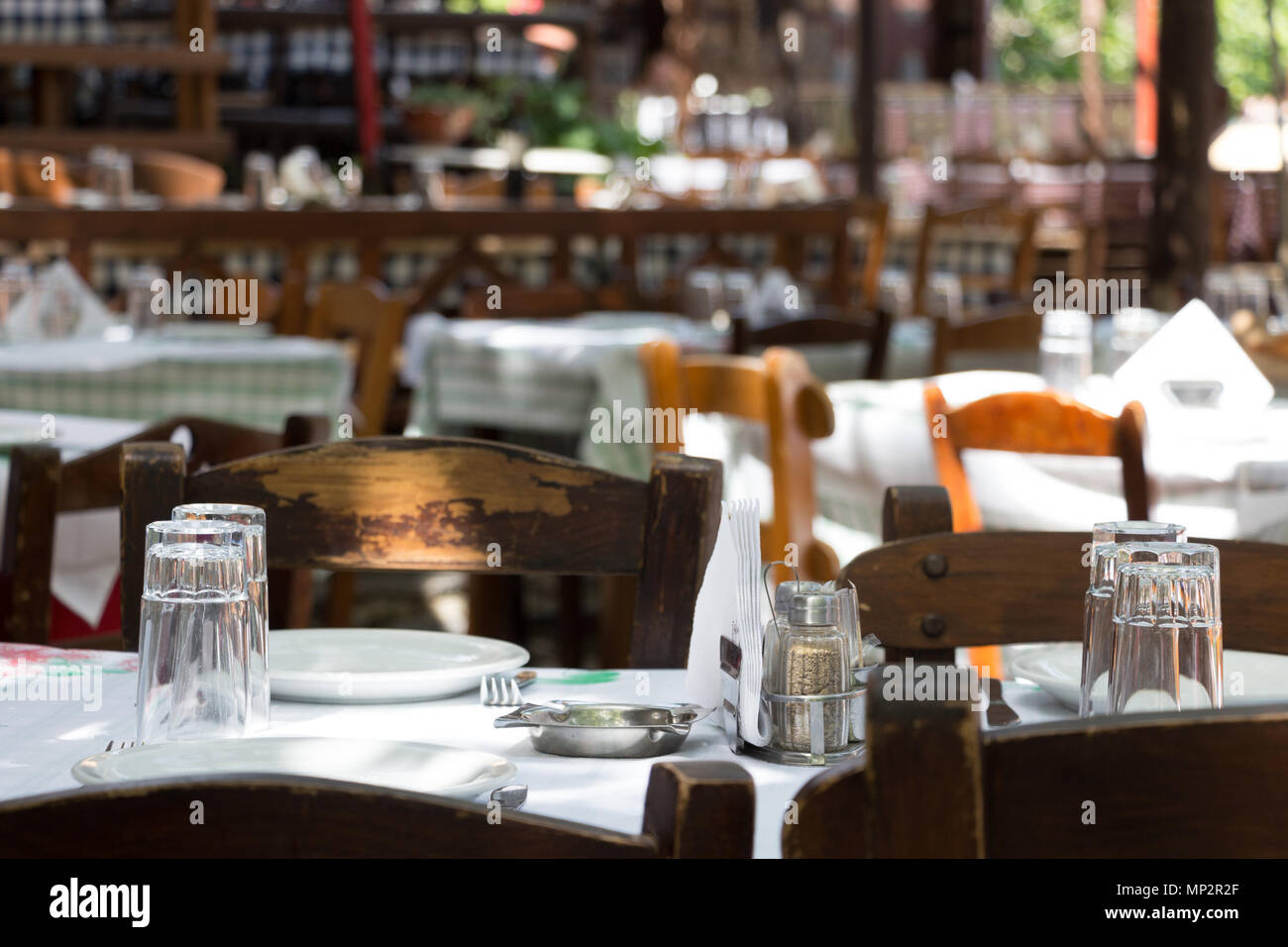 Griechische Taverne mit Tisch und Stühlen im Freien an Palios Panteleimonas, Griechenland. Stockfoto