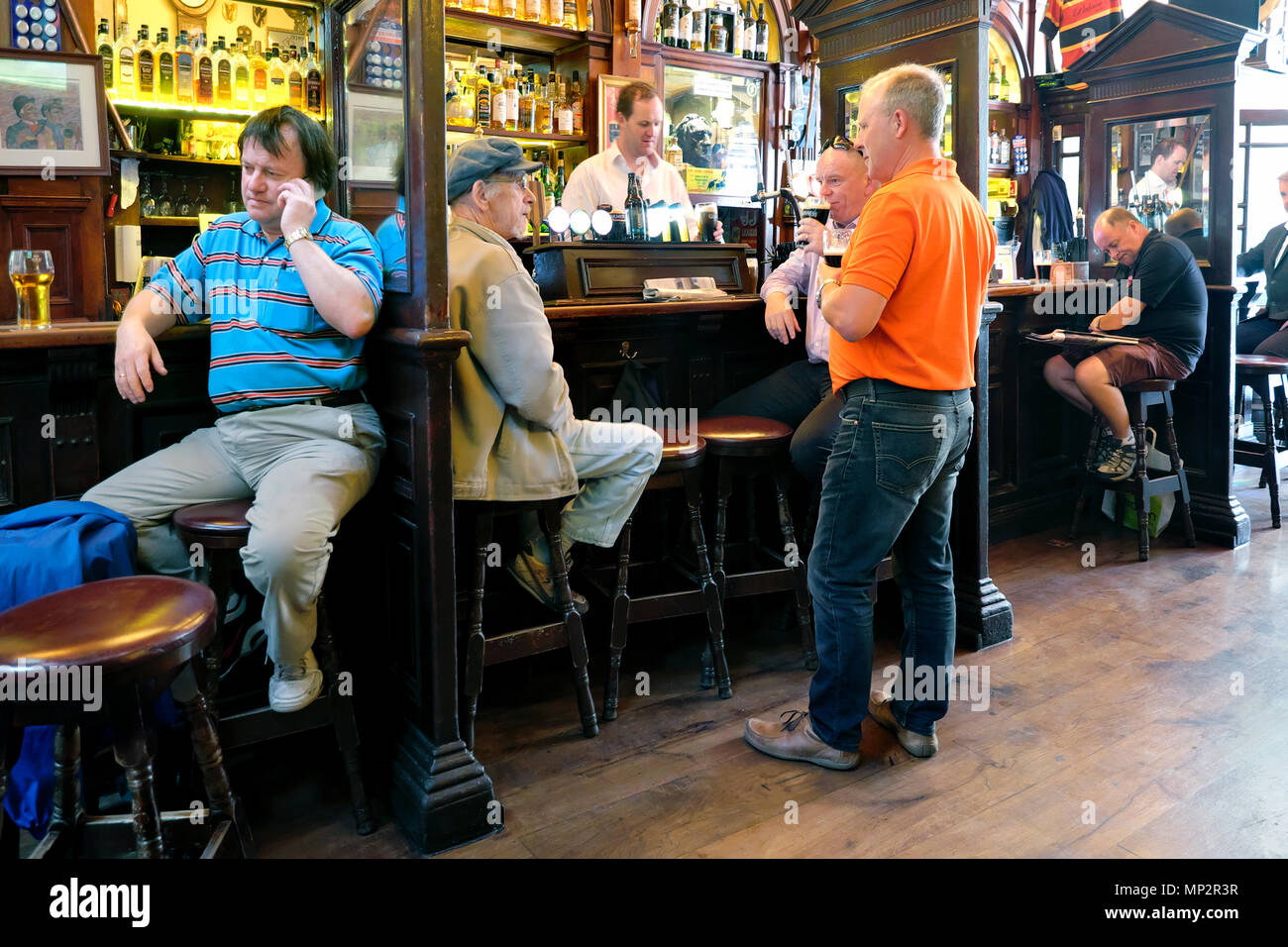 Der Mann spricht auf seinem Handy und Freunde unterhalten sich vor dem Pub-Barkeeper, Der Palace Bar, Temple Bar, Dublin, Irland, Europa Stockfoto