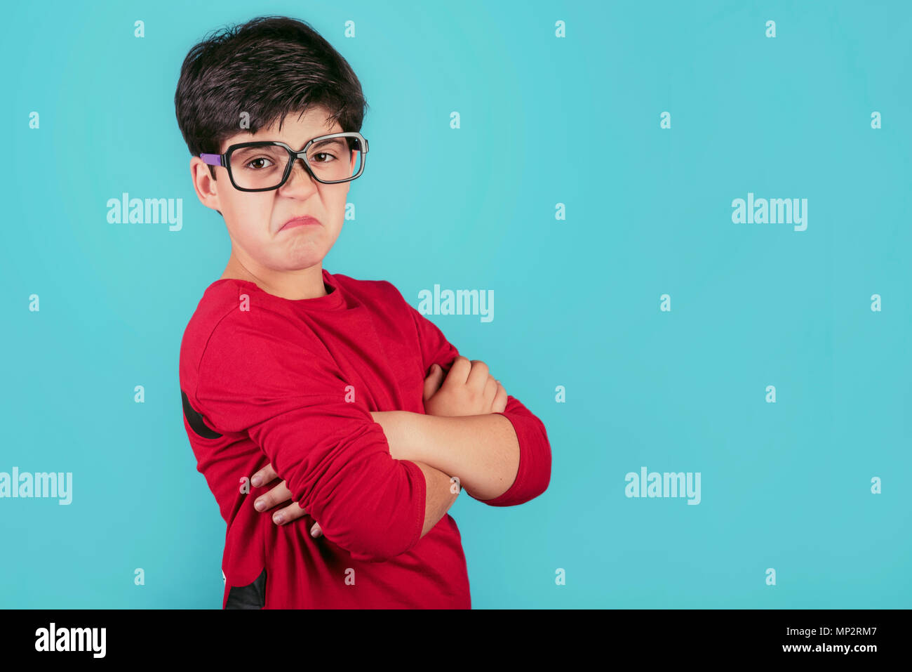 Wütend Junge mit Brille auf blauem Hintergrund wütend Junge mit Brille auf blauem Hintergrund Stockfoto