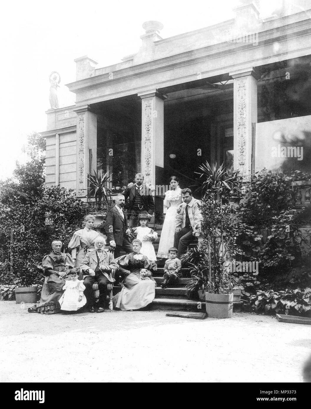 . Englisch: Max Klinger (1857 - 1920, auf dem Foto oben links) mit seiner Familie vor dem Haus seiner Eltern in Leipzig, Karl-Heine-Straße 2 (Gartenseite) English: Max Klinger (1857-1920, im Bild links oben) im Kreise seiner Familie vor der Treppe zum Garten der Villa seiner Eltern in der Leipziger Karl-Heine-Straße 2. ca. 1893. Hermann Walter (1838-1909) 877 Max Klinger mit Familie Stockfoto