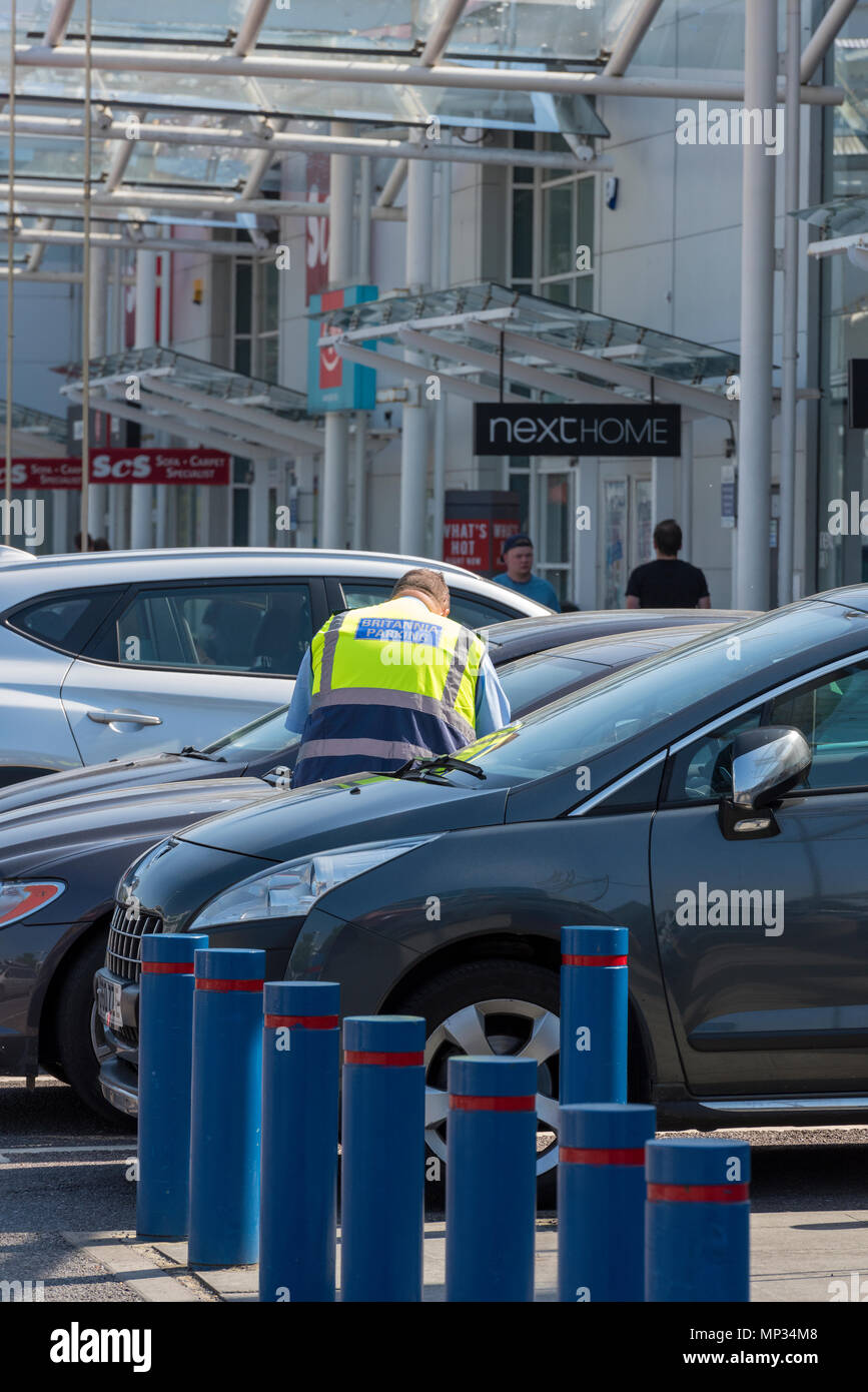 Ein Parkwächter arbeiten in einem Privat kontrollierte Parkzone in einem Retail Park an der West Quay Shopping Centre in Southampton. Private Parkplätze Unternehmen Stockfoto