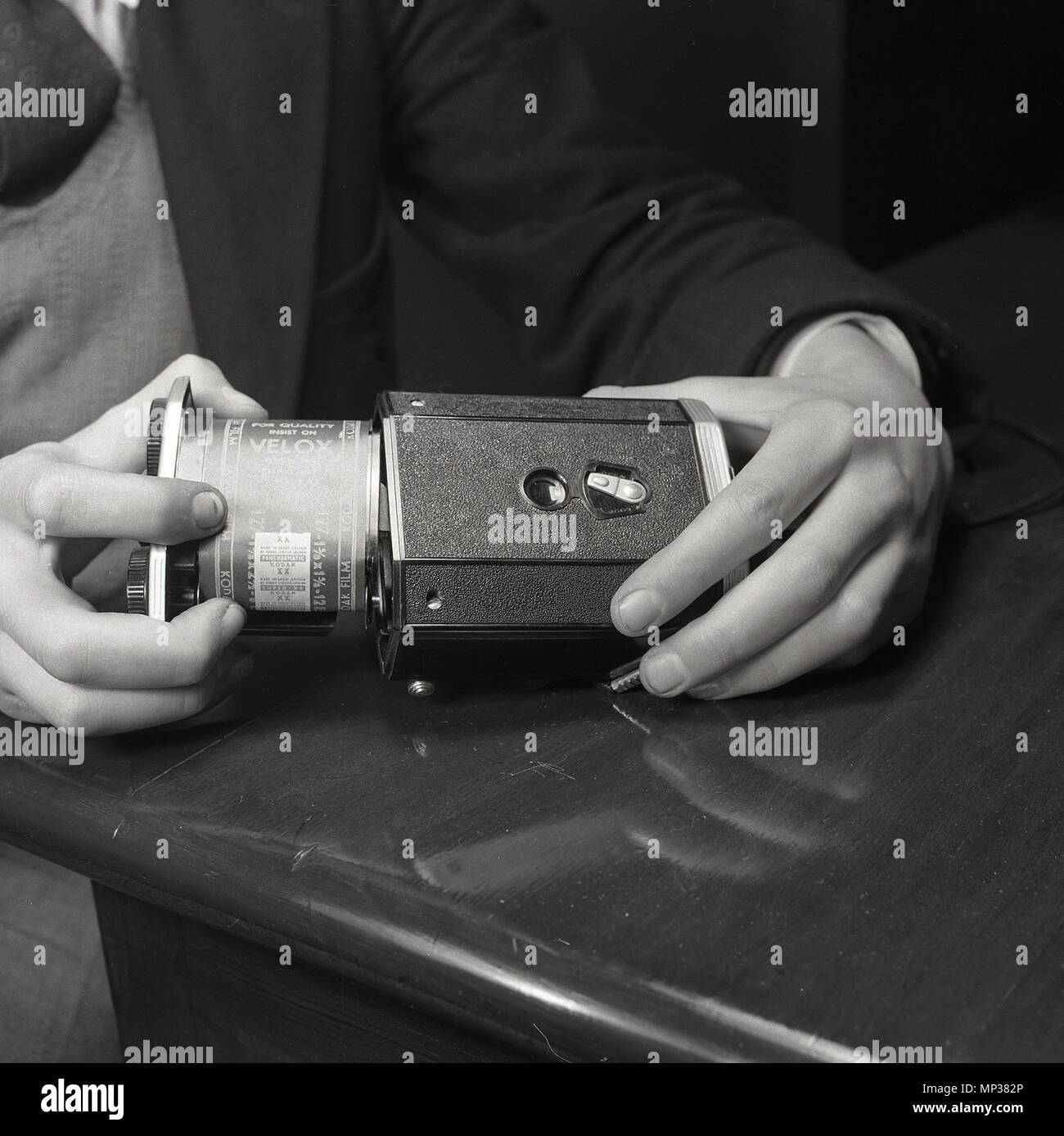 1950 s, historischen, fotografischen Film, 127 negative Rolle Film, in die Rückseite eines Kodak "Brownie" Reflex-Kamera geladen wird. Die Brownies Reflex war ein populäres Modell in dieser Ära, besonders unter jungen Leuten, preiswert, aber als Medium Format und gut genutzt, würden gute Ergebnisse erzielt werden. Stockfoto 1950 s, historischen, fotografischen Film, 127 negative Rolle Film, in die Rückseite eines Kodak "Brownie" Reflex-Kamera geladen wird. Die Brownies Reflex war ein populäres Modell in dieser Ära, besonders unter jungen Leuten, preiswert, aber als Medium Format und gut genutzt, würden gute Ergebnisse erzielt werden. Stockfoto