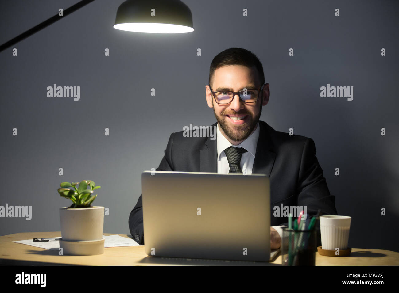 Glücklich Mann lächelt in die Kamera während im Büro arbeiten Stockfoto