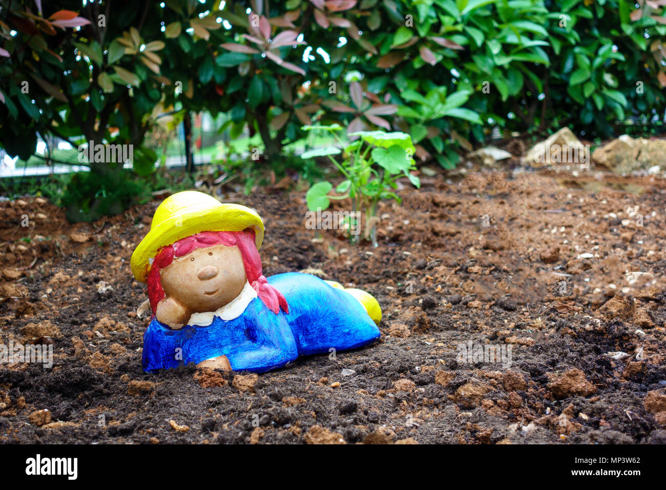 Gartenzwerg, Zwerg auf Boden, bunte Mädchen als Gärtner Stockfotografie
