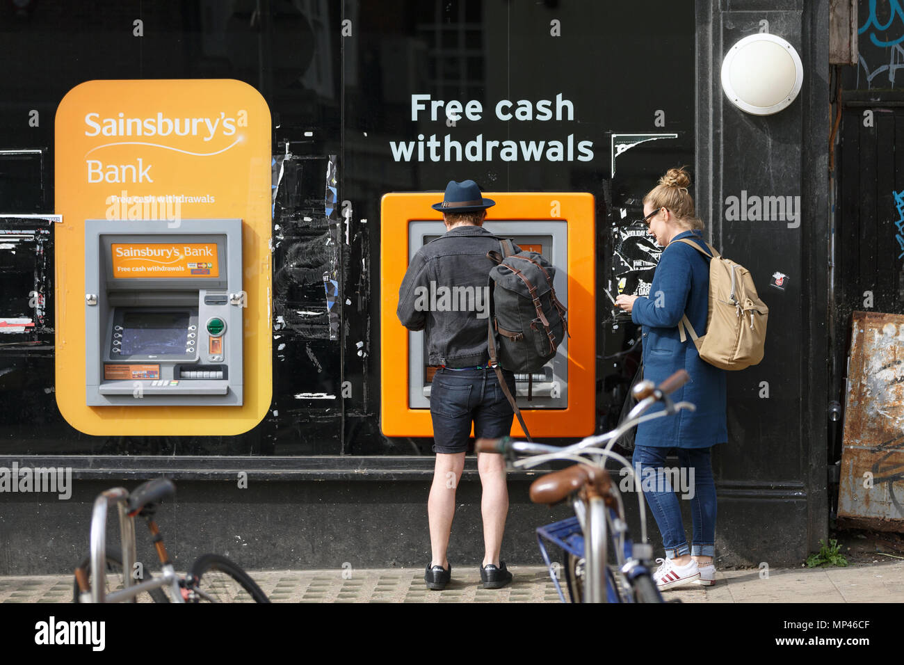 Ein Mann Geld abheben von einem Sainsbury ATM. Stockfoto