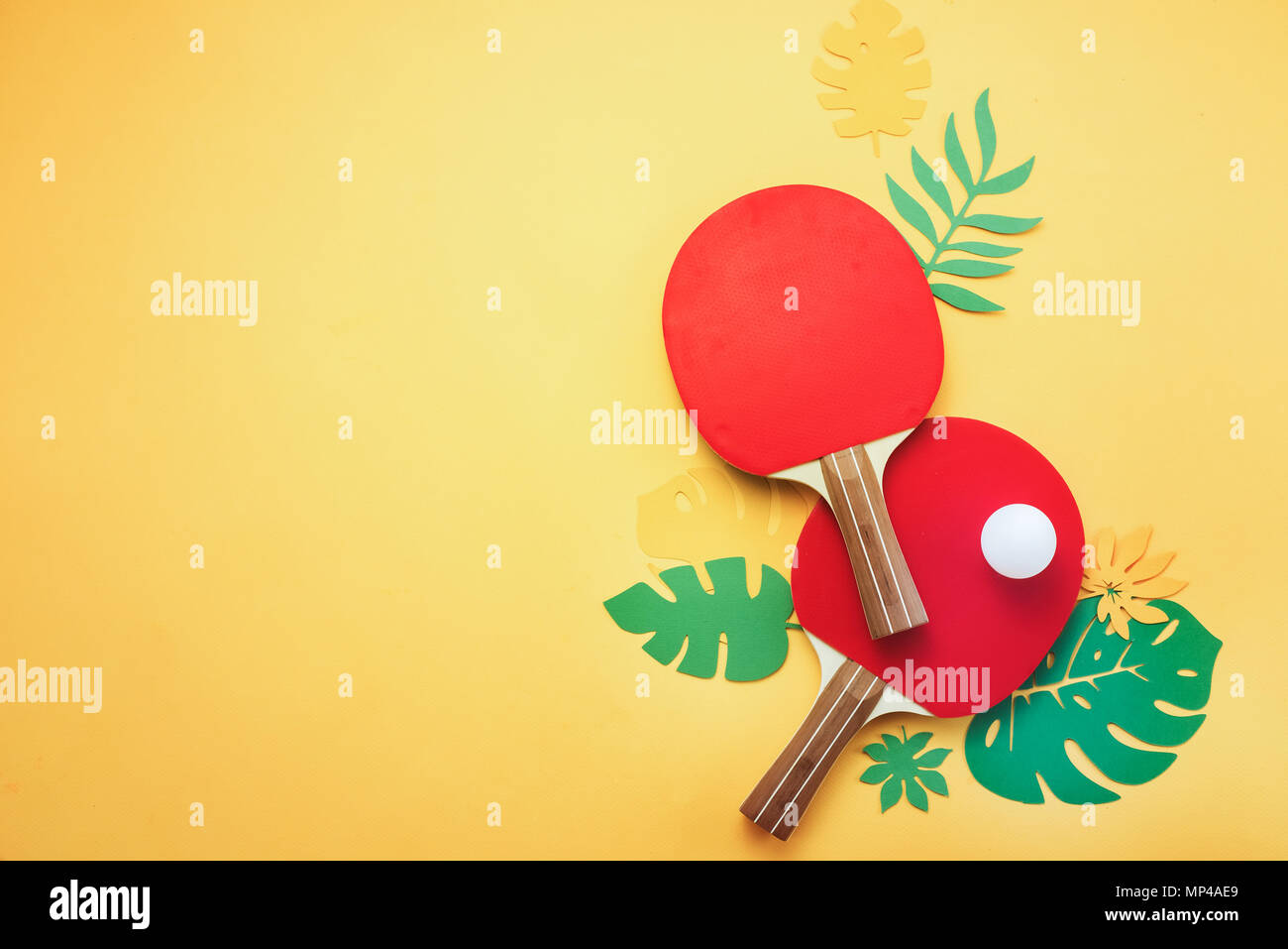 Ping pong Schläger und Ball mit tropischen Blättern. Sommer Sport und Freizeit flach auf einem sonnigen Gelb Hintergrund mit kopieren. Stockfoto