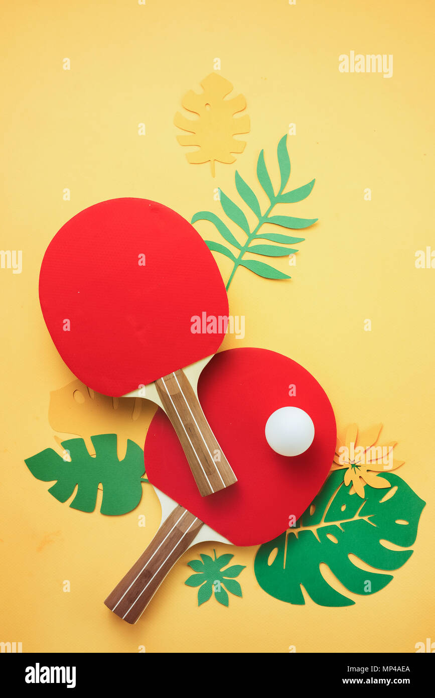 Ping pong Schläger und Ball mit tropischen Blättern. Sommer Sport und Freizeit flach auf einem sonnigen Gelb Hintergrund mit kopieren. Stockfoto