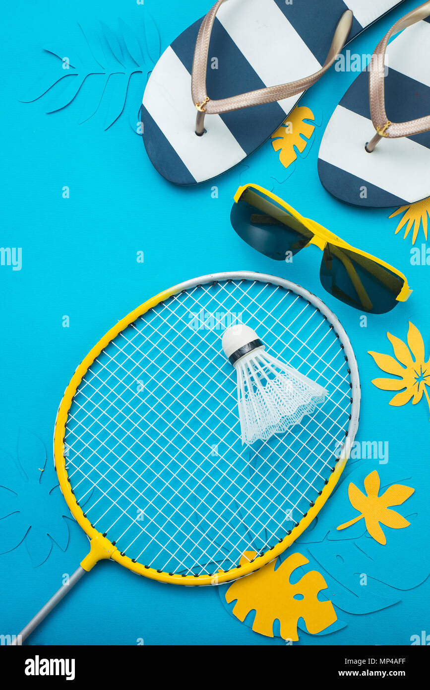 Badminton Strand, Flip flopsm Sonnenbrille und tropische Blätter. Sommer Sport und Freizeit flach auf einem blauen Hintergrund mit kopieren. Stockfoto
