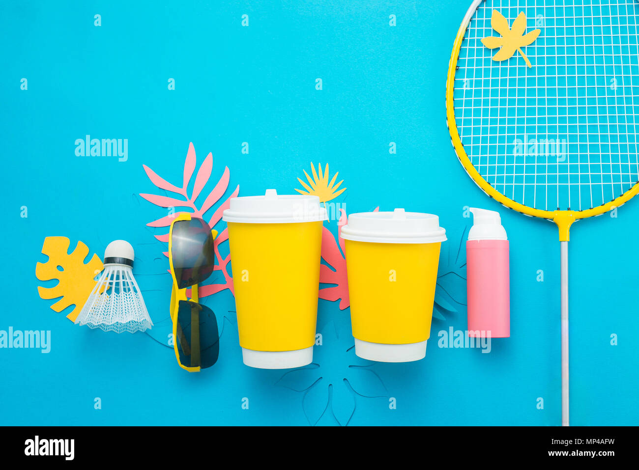 Sommer Sport header. Badminton Rakete mit tropischen Blättern, Flip Flops, Sonnenbrille, Sonnencreme und Papier Schale von oben auf einem hellen blauen Hintergrund wi Stockfoto
