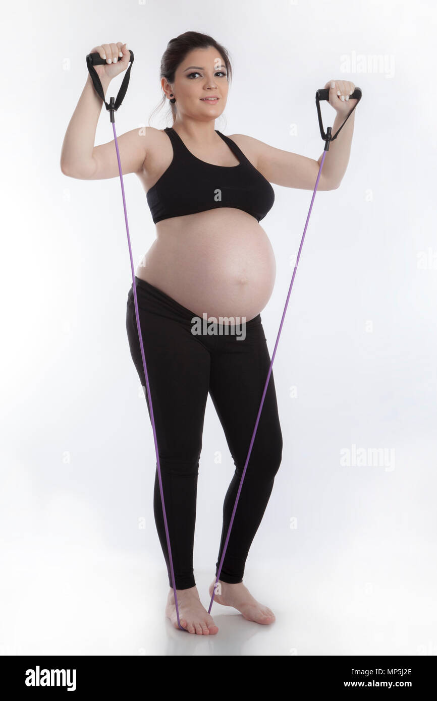 Schwangere tun gymnastischen Übungen auf weißem Hintergrund Stockfoto