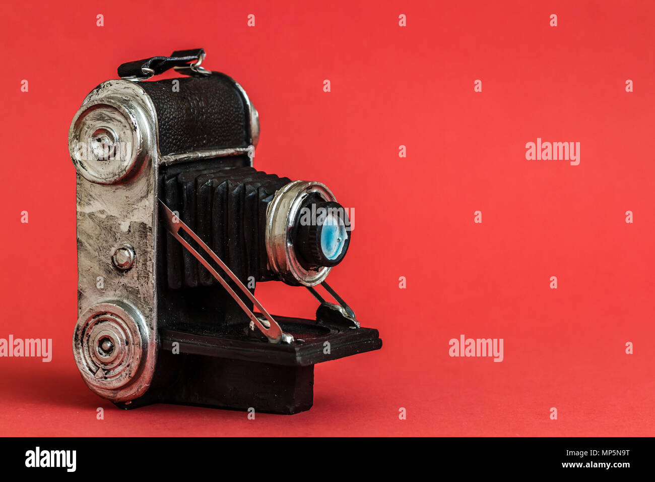 Dekorative nostalgische Kamera Figürchen auf rotem Hintergrund Stockfoto