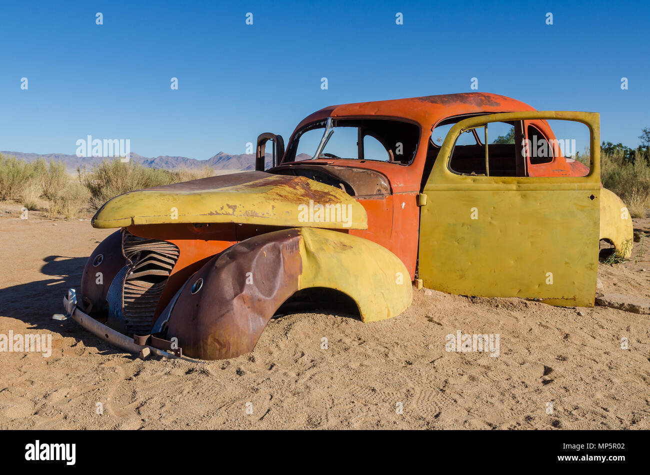 Rote und gelbe aufgegeben Classic Car in der Namib Wüste in der Nähe von Solitaire, Namibia Stockfoto