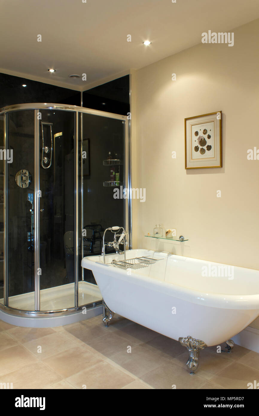 Ein modernes Bad mit glänzendem Chrom Duschkabine und Badewanne mit Standfuß Stockfoto