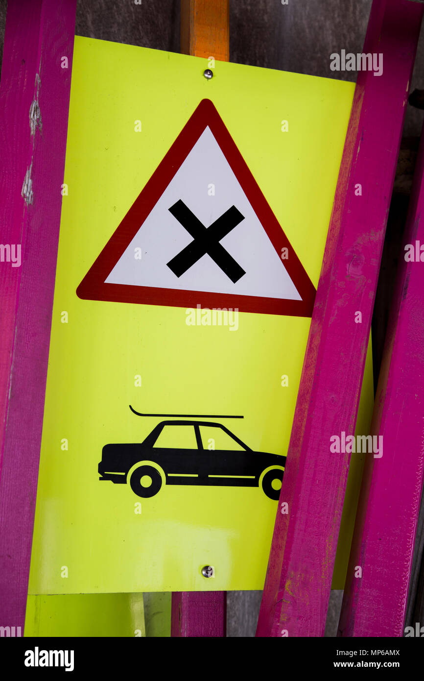 Schild gefährliche Kreuzung mit Auto und Ski-Rack und Polen in Lagerung im Skigebiet Stockfoto