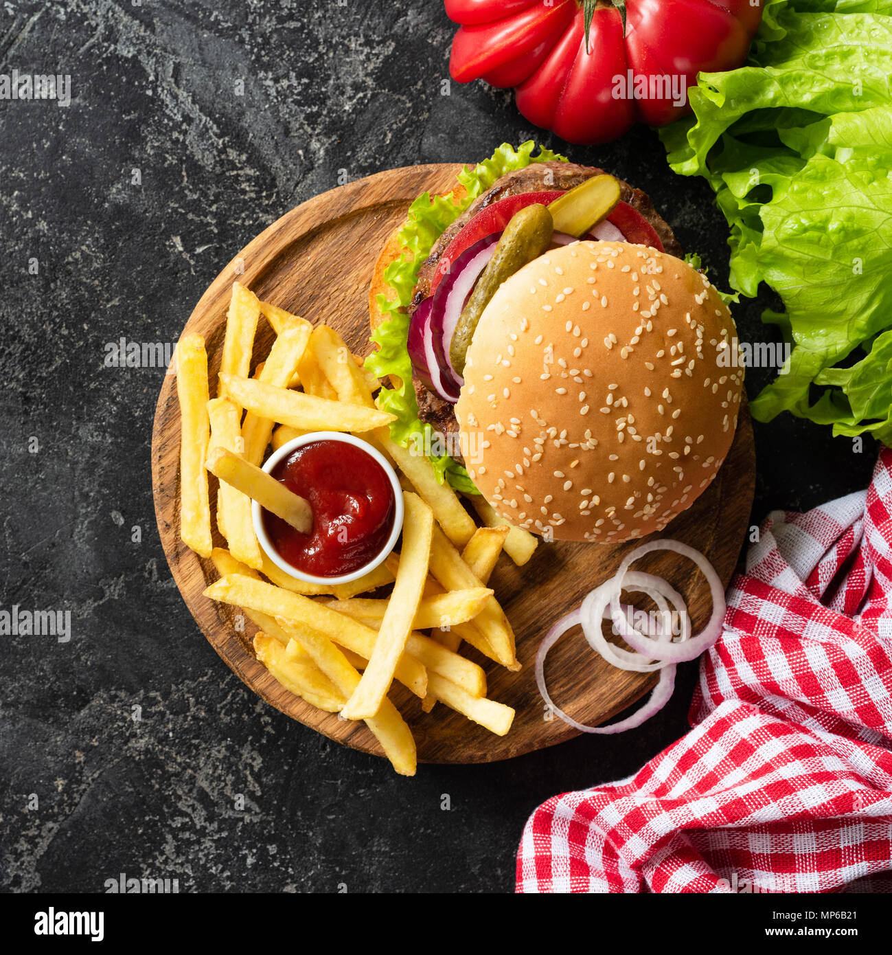 Leckere Burger mit Rindfleisch, Pommes frites und Ketchup auf dunklem
