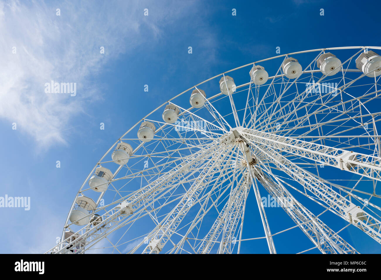 Ein Riesenrad, oder Big Wheel, bei einer Messe vor blauem Himmel. Stockfoto