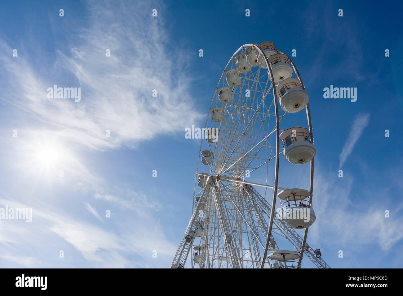Ein Riesenrad, oder Big Wheel, bei einer Messe vor blauem Himmel. Stockfoto