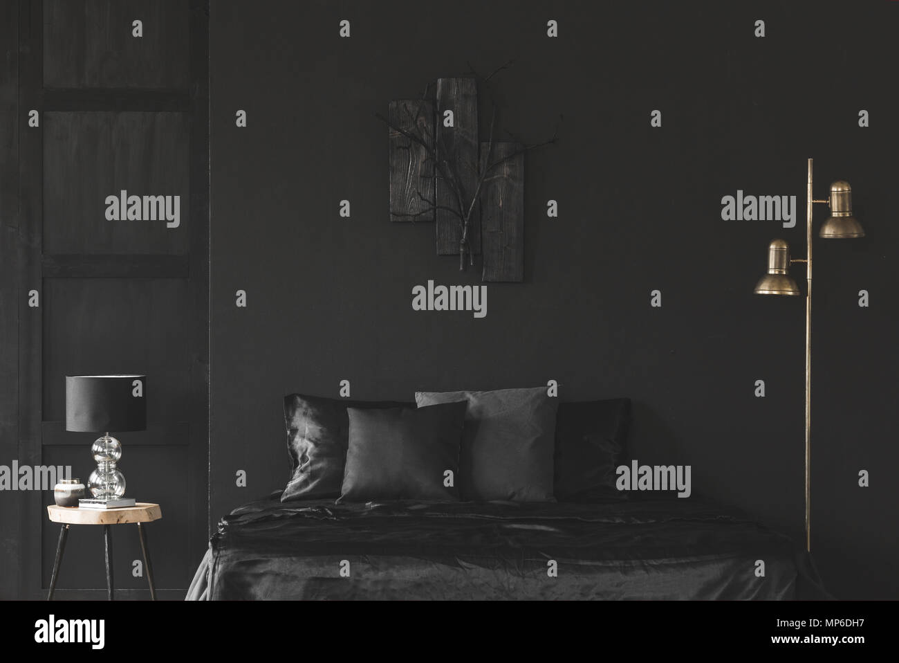 Gold Lampe neben dem Bett im Schlafzimmer schwarz Innenbereich mit Skulptur auf dunklen Wand Stockfoto