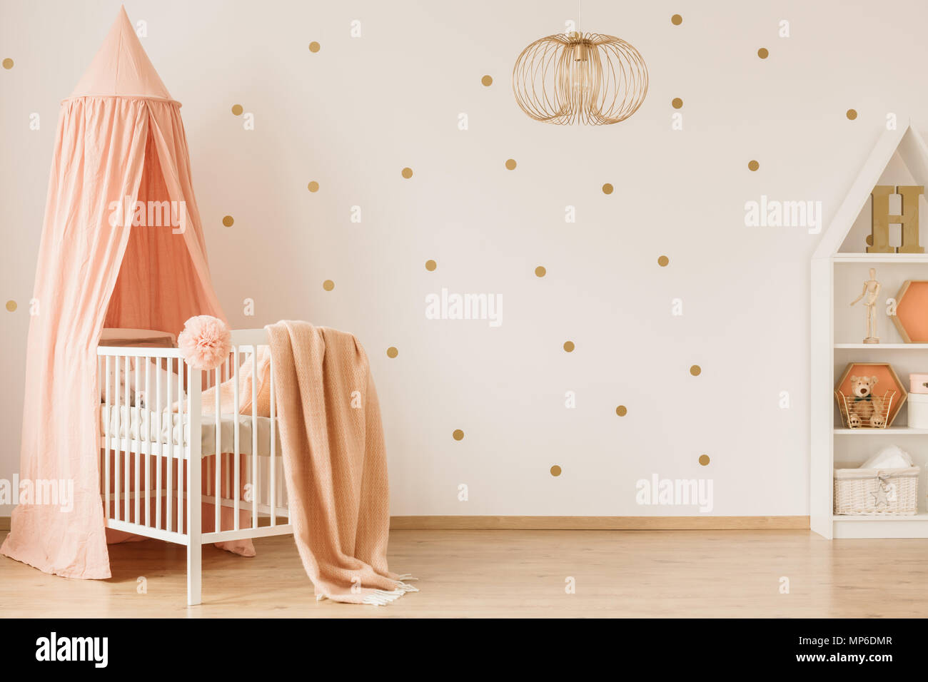 Hell baby girl Inneneinrichtung mit gepunkteten Wand, Pastell rosa Akzente und gold Dekor Stockfoto