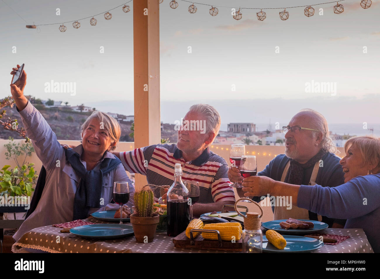 Gruppe der Erwachsenen Freunde ältere Menschen im Ruhestand Spaß ein Bild wie selfie alle zusammen bei einem Abendessen im Freien auf der Terrasse Dachterrasse feiern. Stockfoto