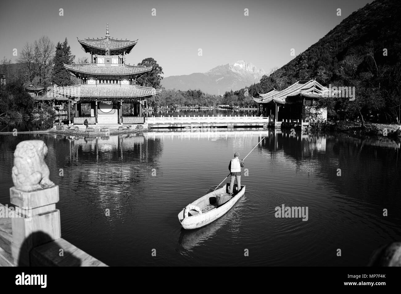 Ein alter Mann auf dem Schiff in der Pool des Schwarzen Drachens (Altstadt von Lijiang, Yunnan, China) Stockfoto